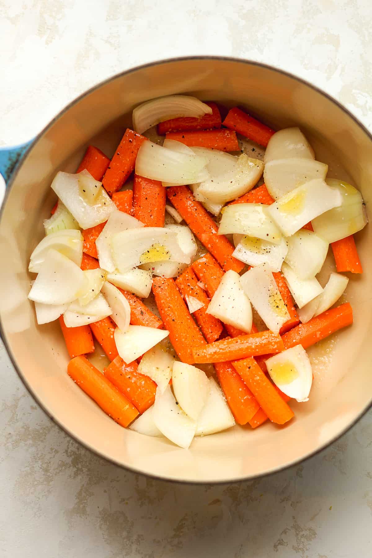 The carrots and onions in the pot.