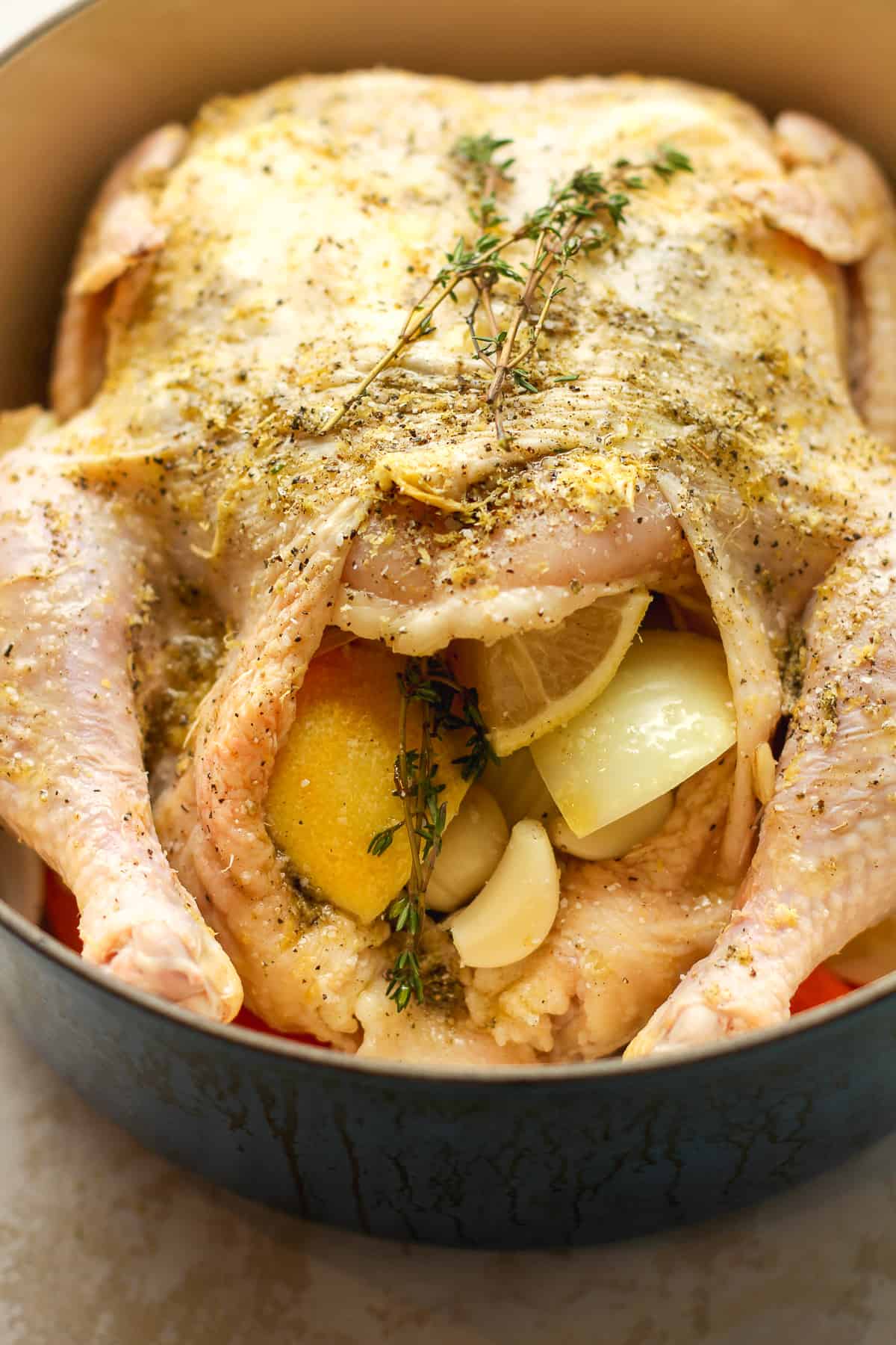 A raw chicken prepped for baking.