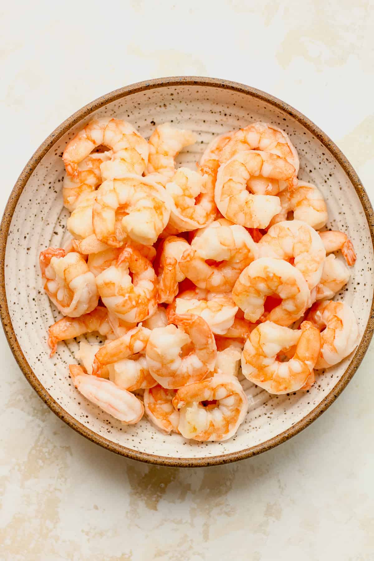 A bowl of cooked shrimp.