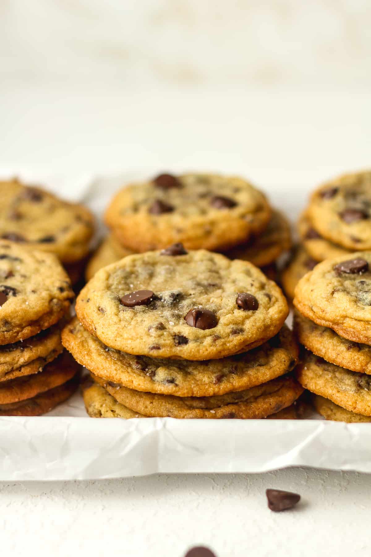 Side view of a tray of stacked chocolate chip cookies.