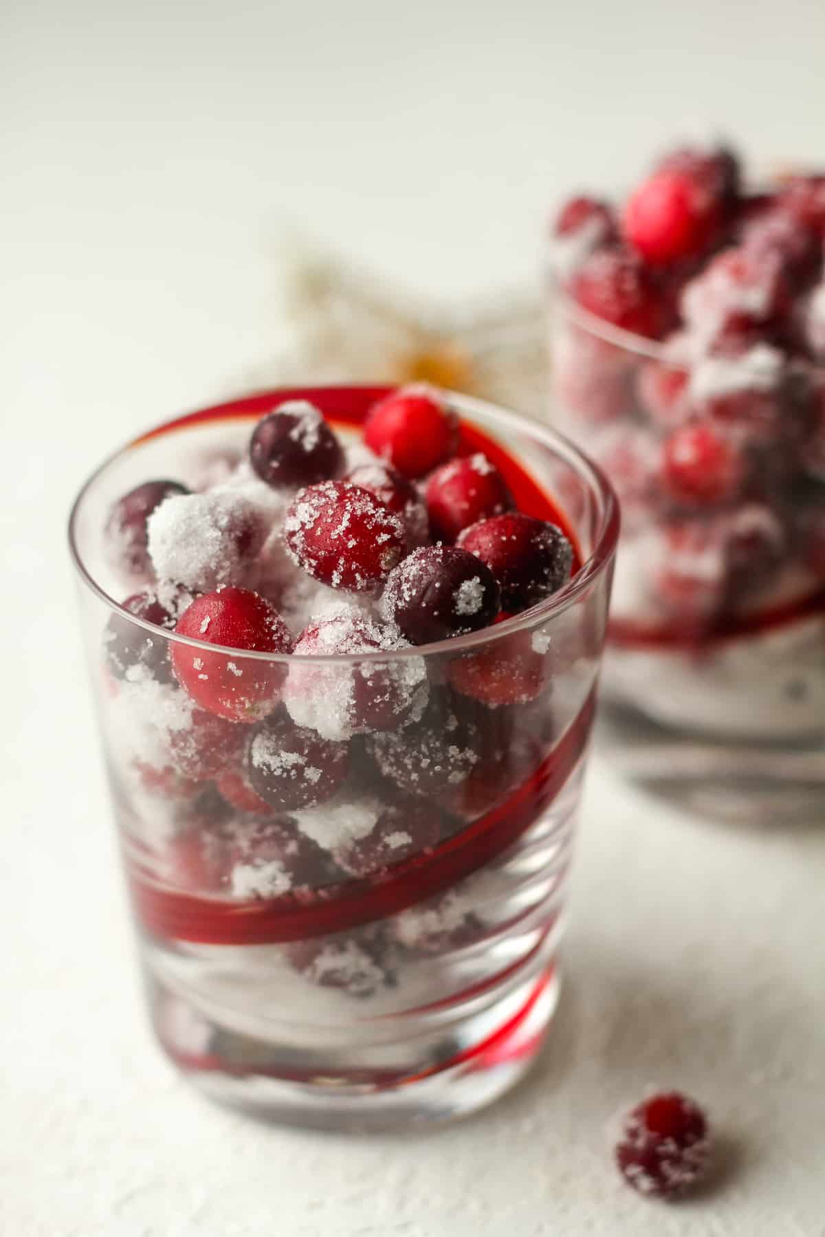 Side view of a glass of sugared cranberries.