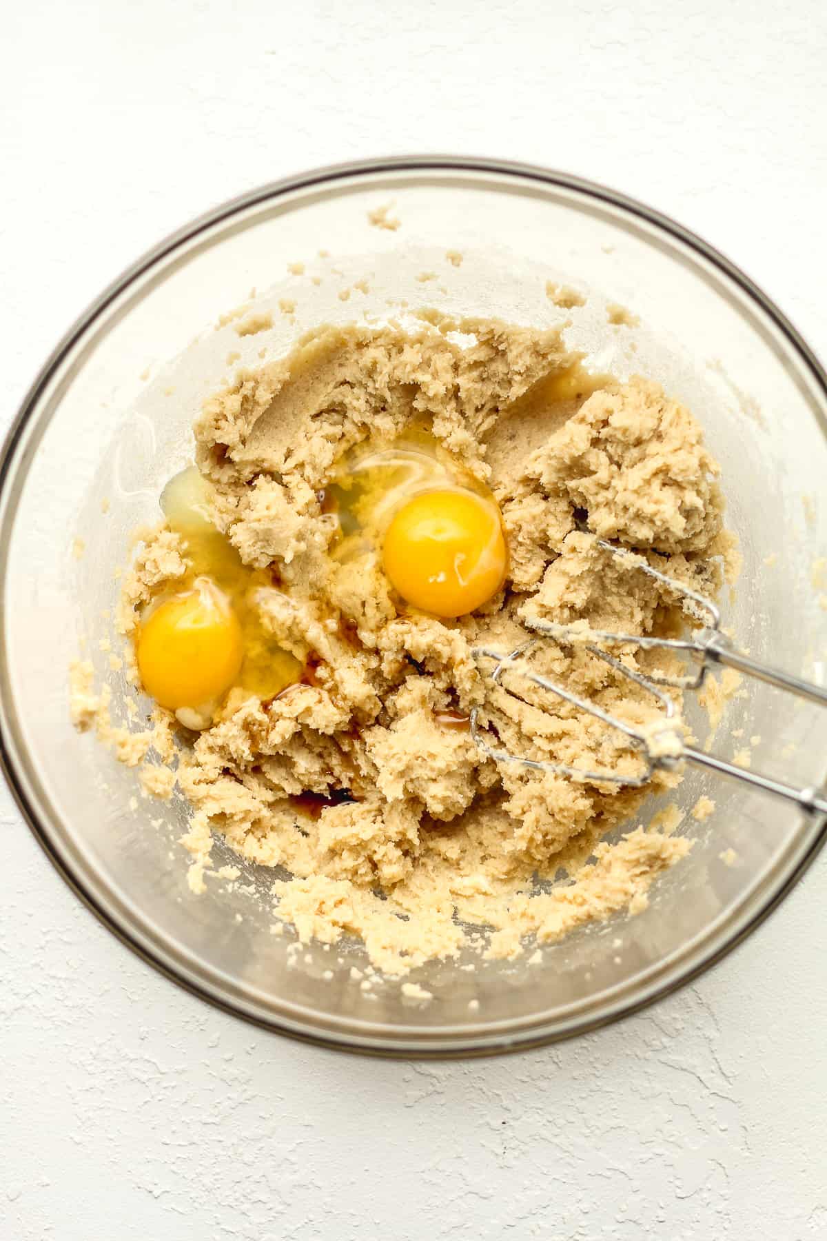 A bowl with the wet ingredients with eggs on top.