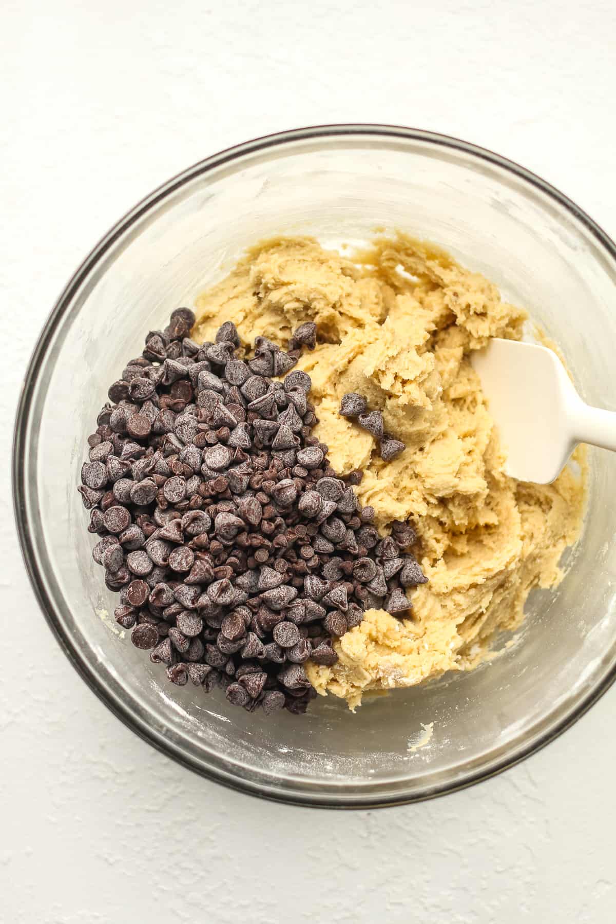 A bowl of the cookie dough with chocolate chips on top.