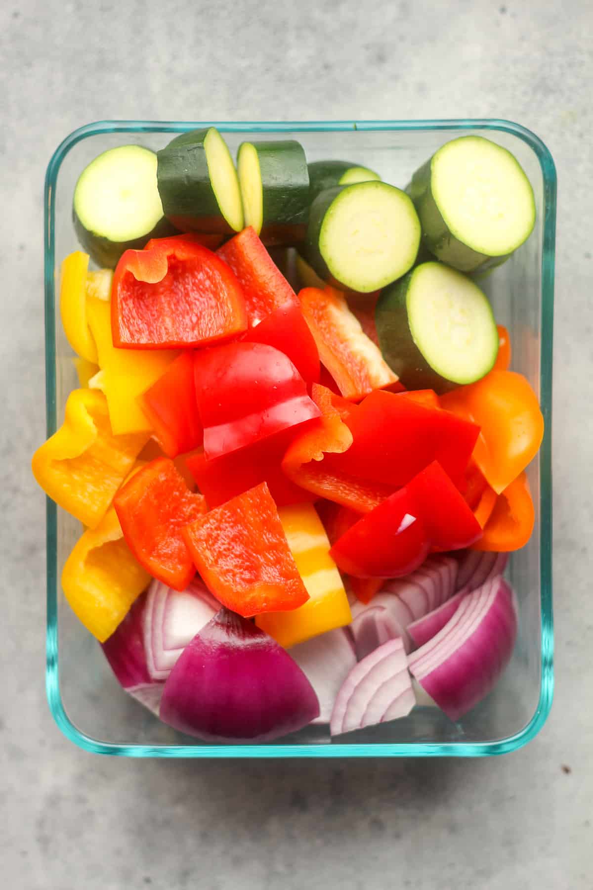 A rectangular glass bowl with chopped veggies.