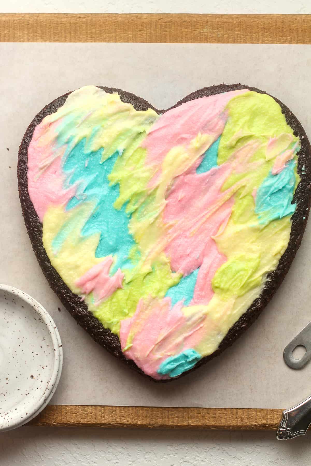 A heart shaped cake with colorful buttercream frosting.