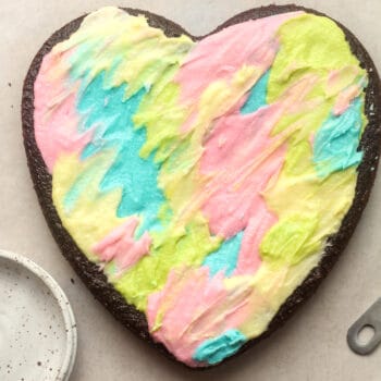 Closeup on a chocolate heart shaped cake with colorful buttercream.