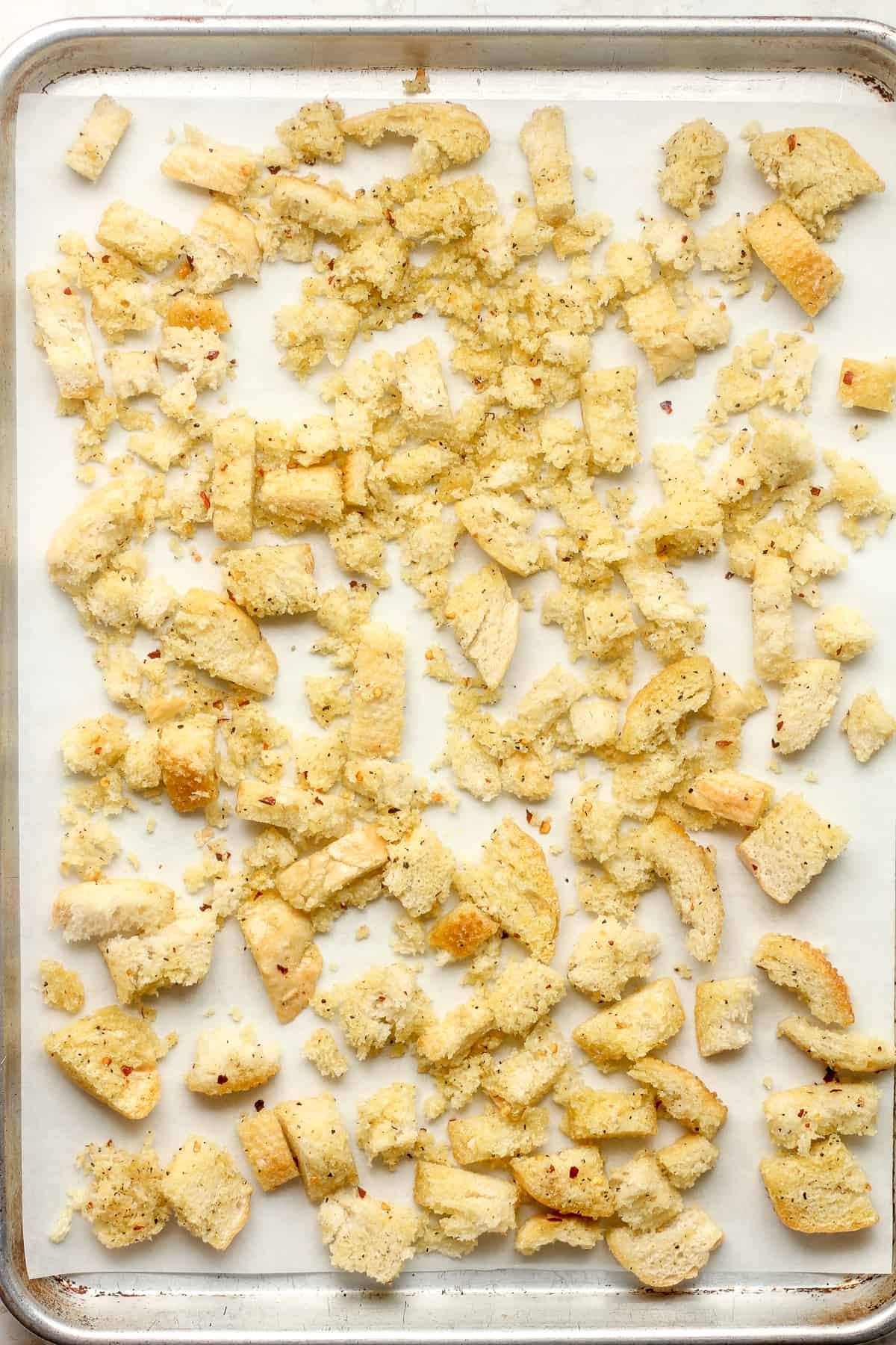 The prepped croutons on a baking sheet before baking.