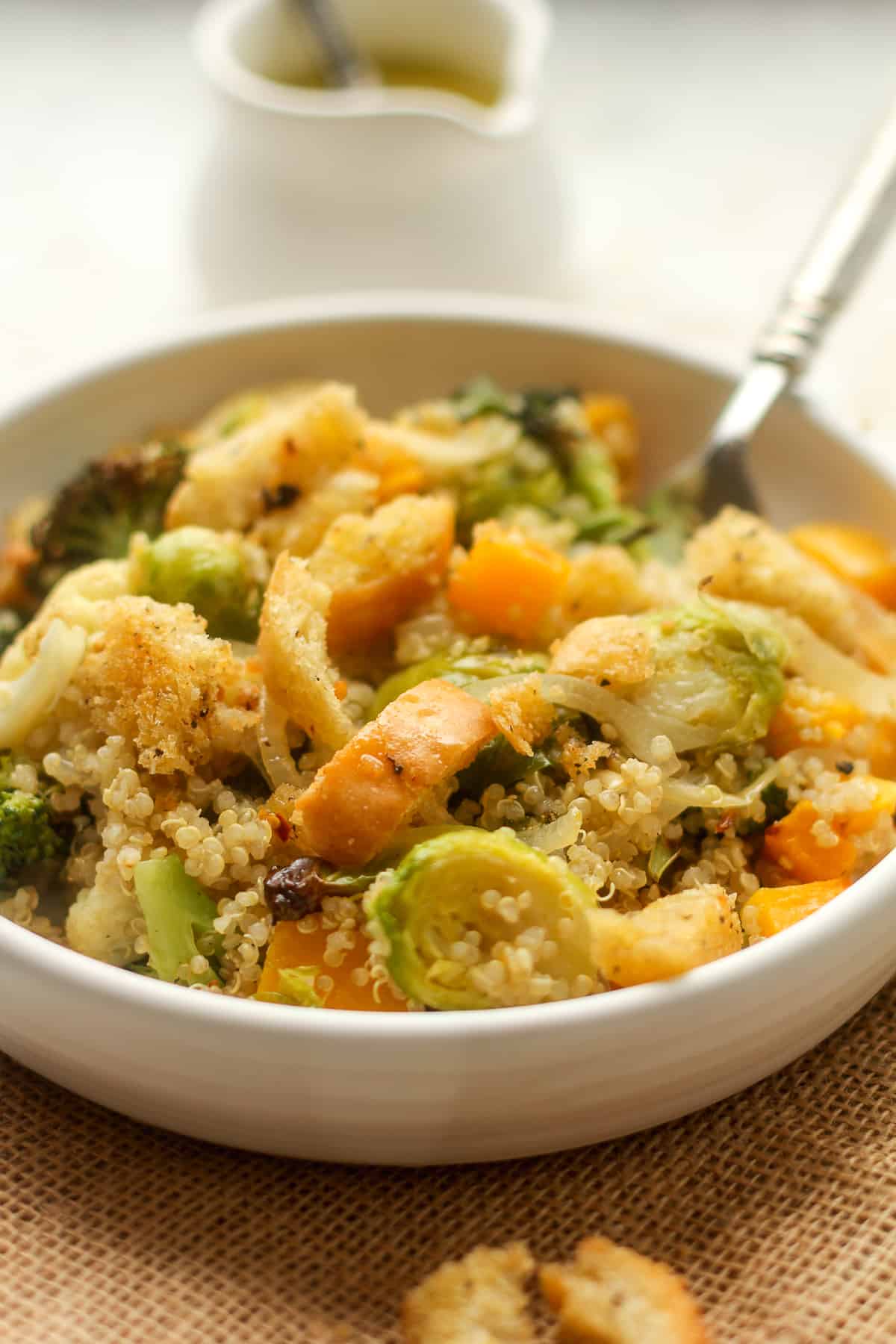 Side view of a serving of quinoa salad with roasted veggies.