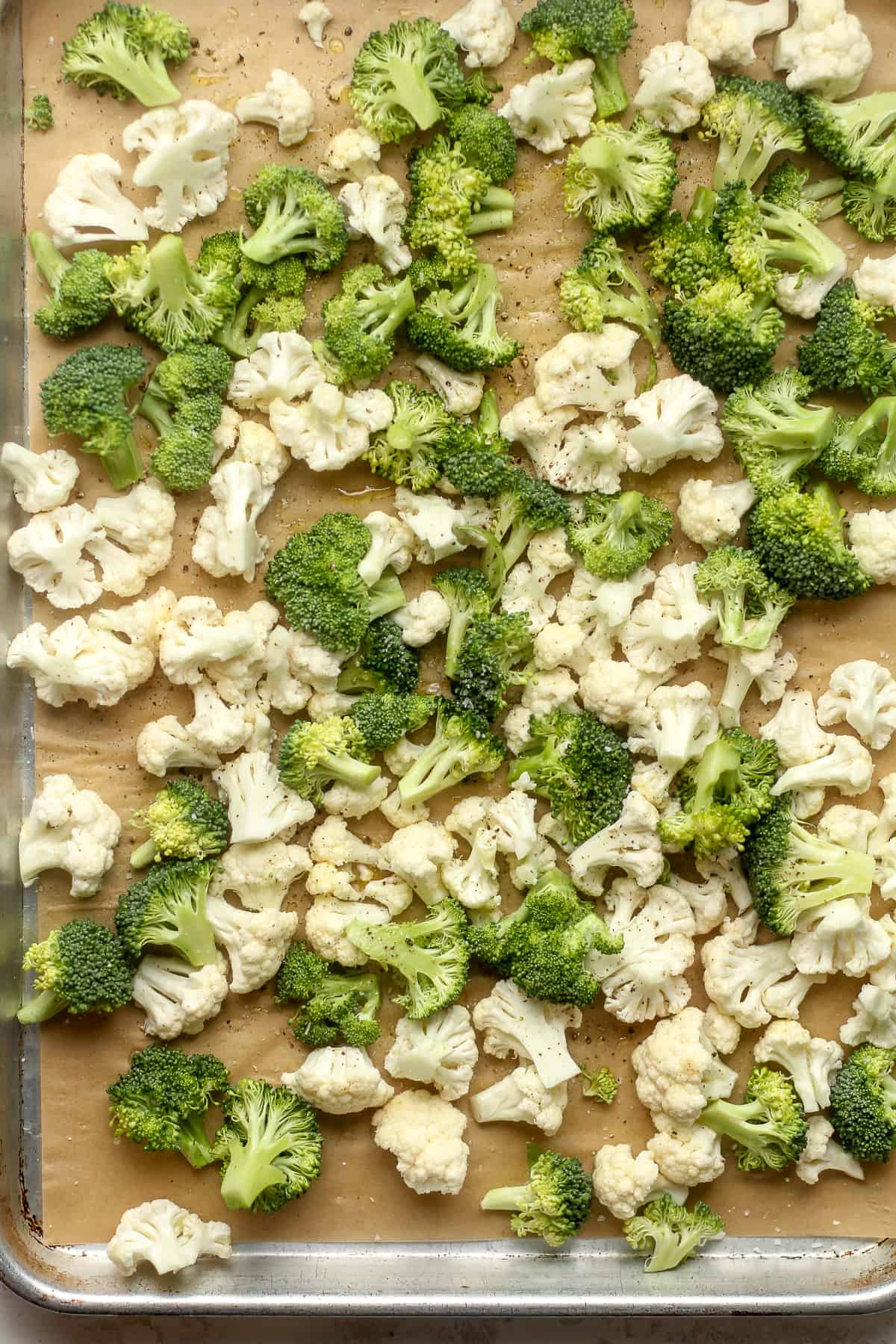 The raw broccoli and cauliflower on a sheet pan.