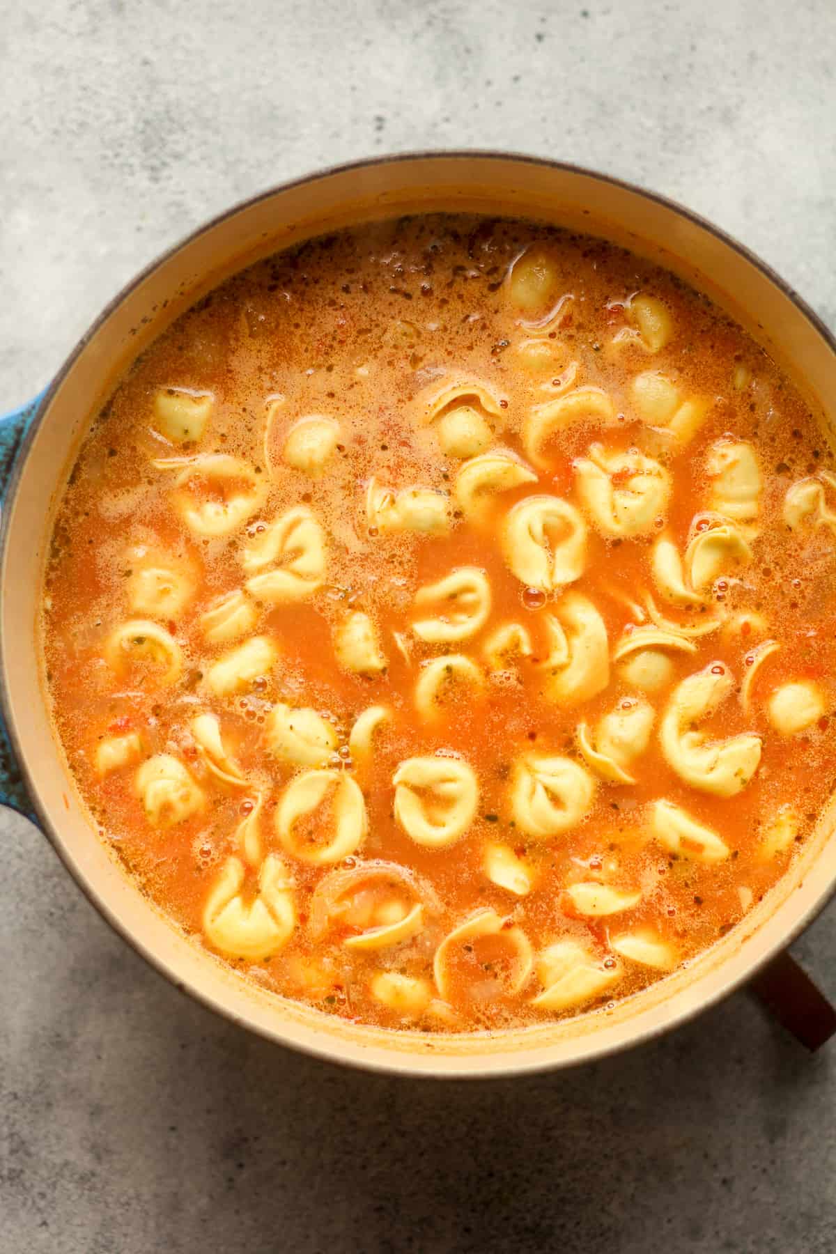 A pot of soup after adding tortellini.