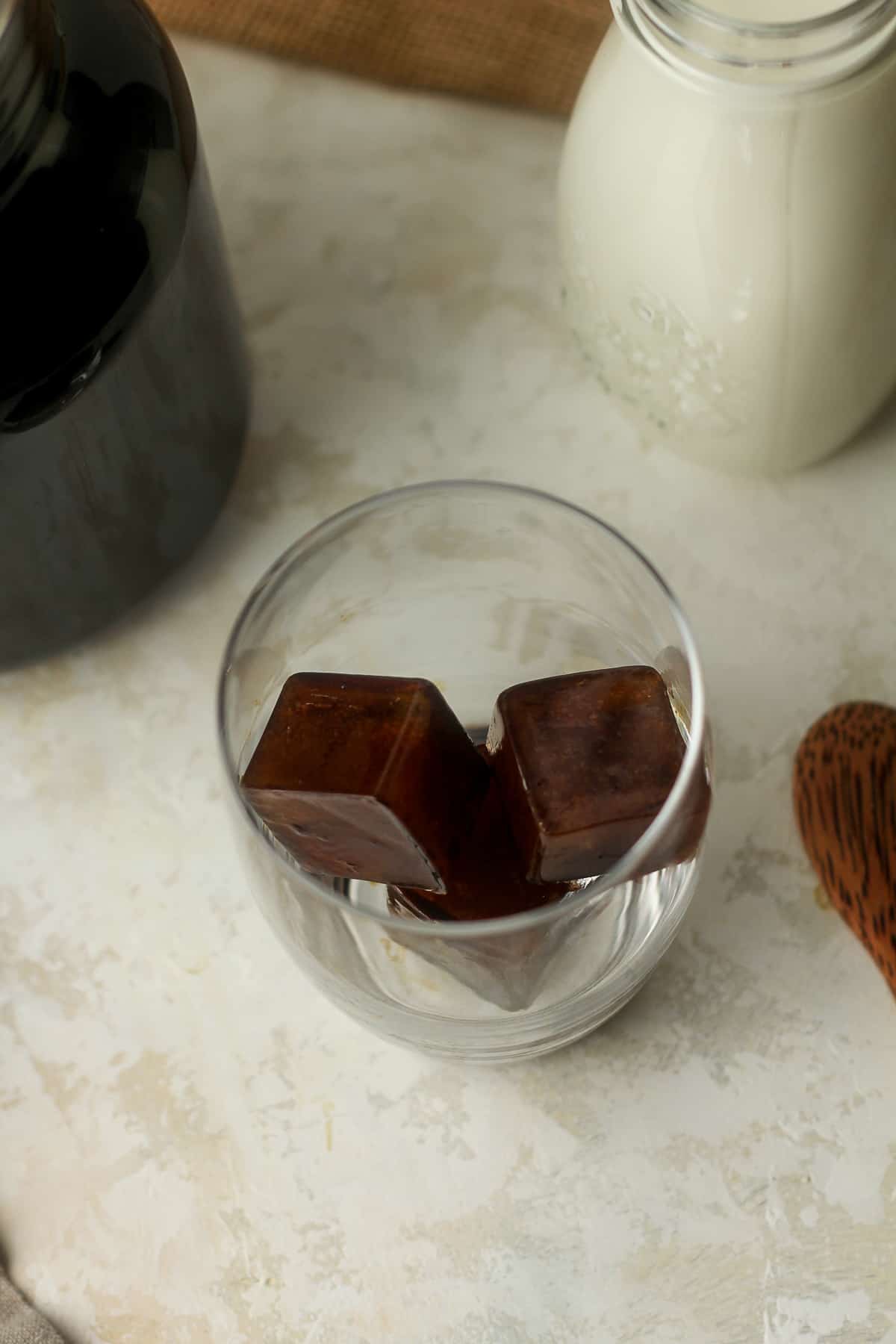 A glass with three small coffee cubes.