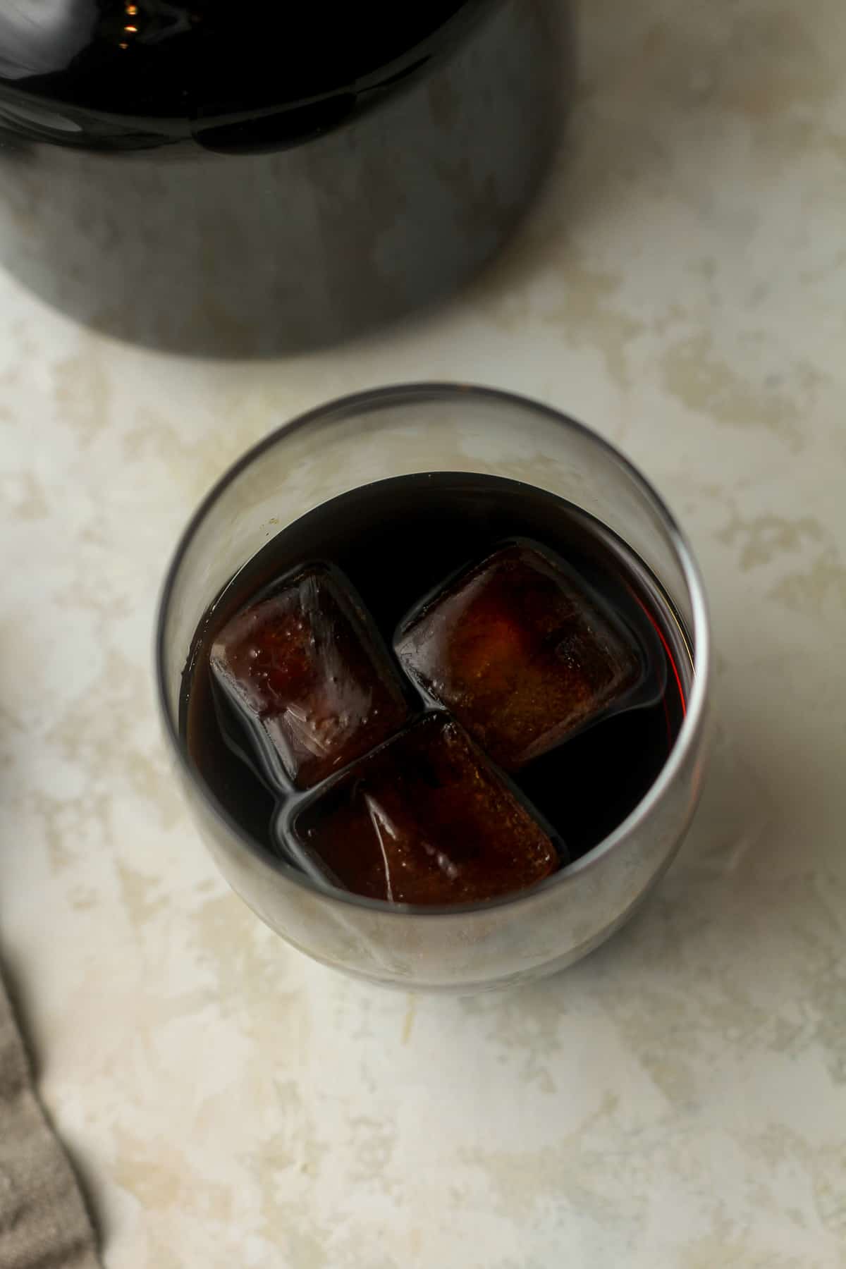 A glass of coffee cubes with cold brew on top.