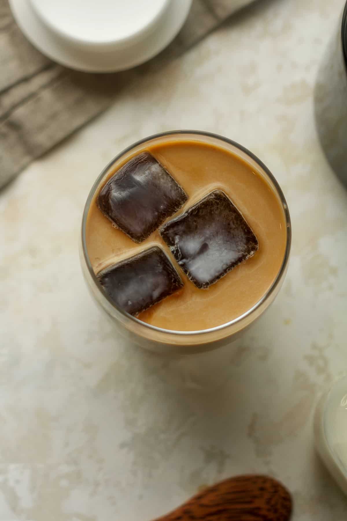 Overhead view of a glass of cold brew with coffee cubes.