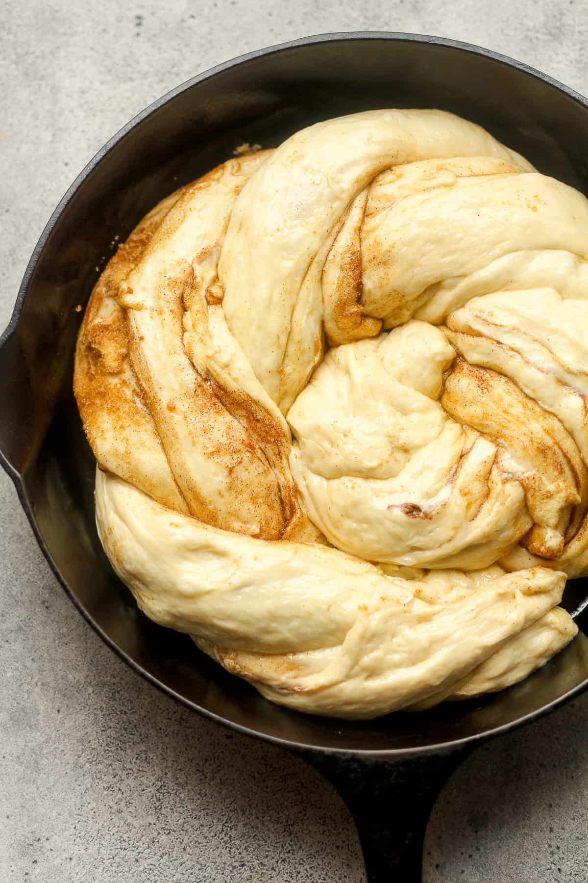 A cinnamon twist roll after placing in the skillet.