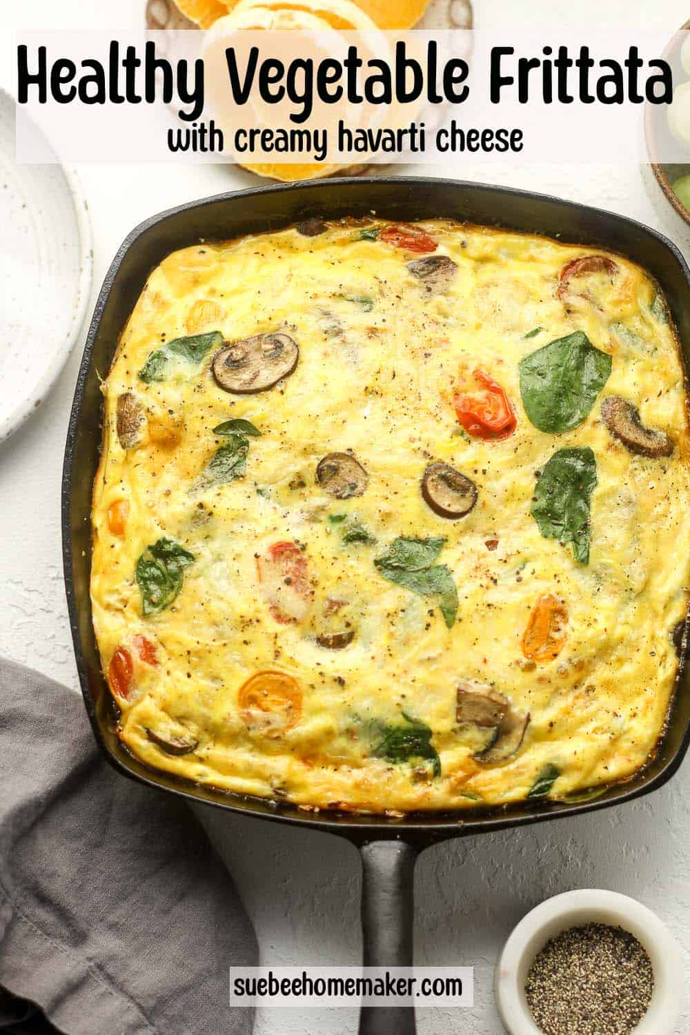 A square cast iron skillet with a baked veggie frittata.