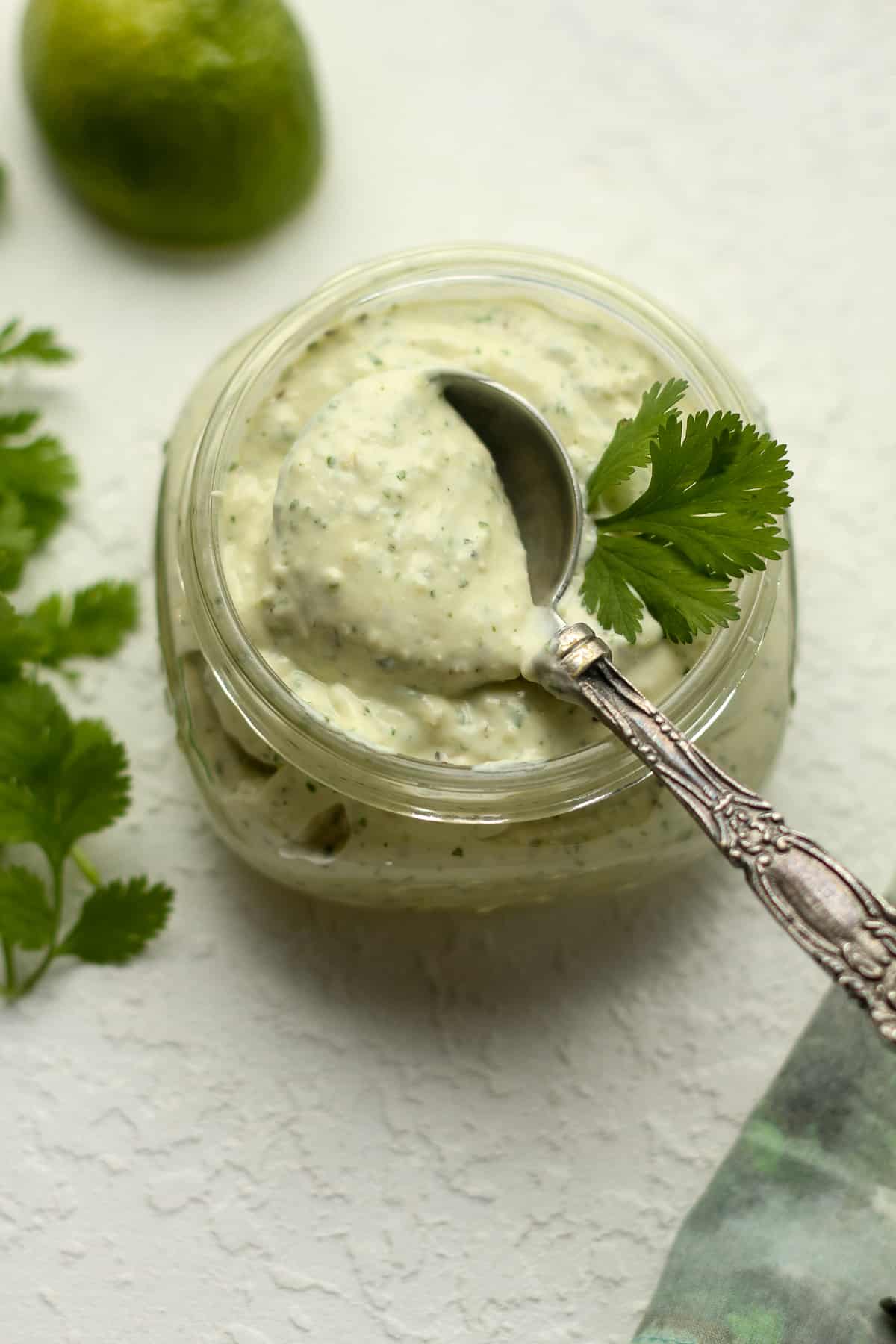 Overhead view of a jar of jalapeno ranch dressing with a tablespoon on top.