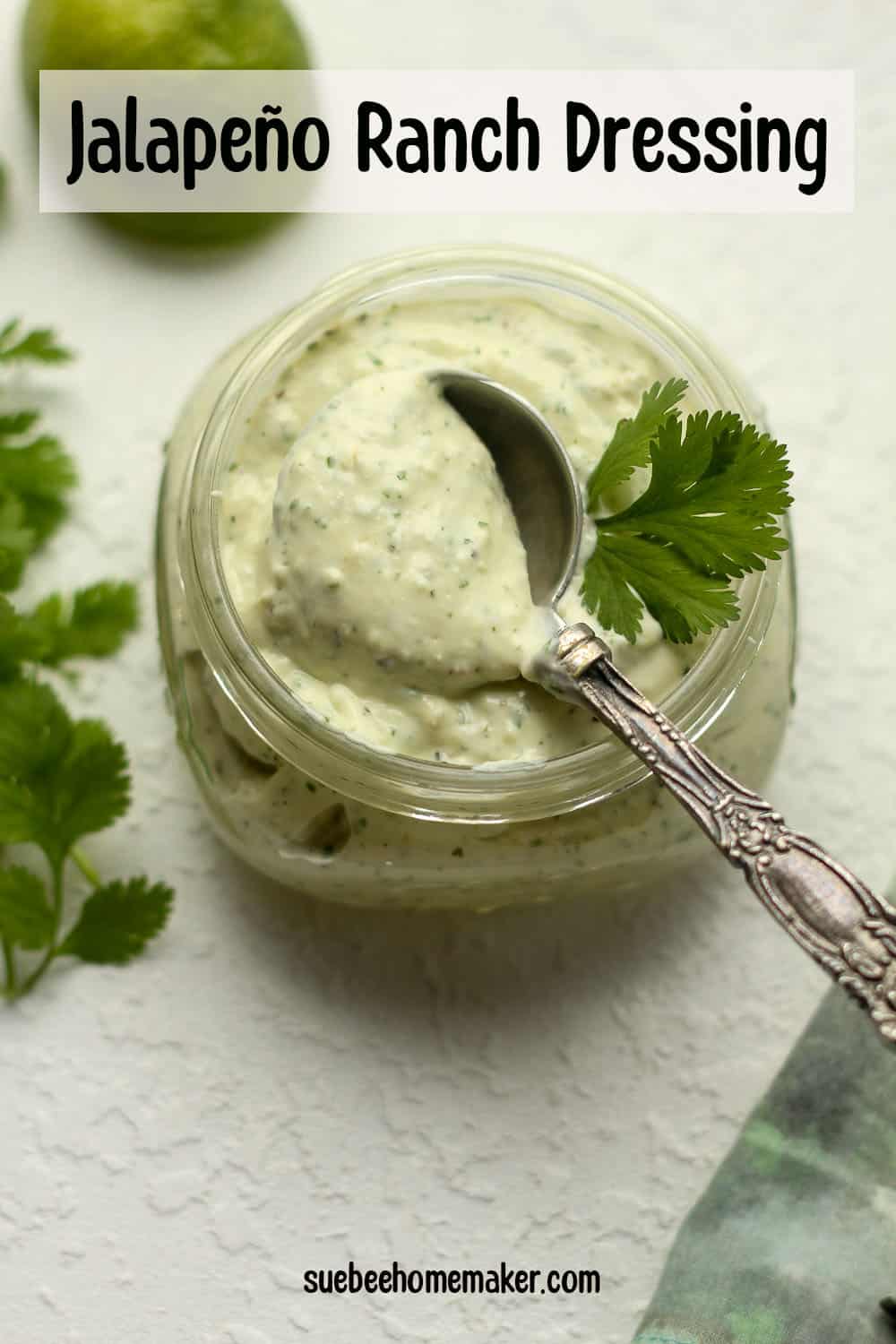 A jar of jalapeno ranch with a tablespoon dipped in.