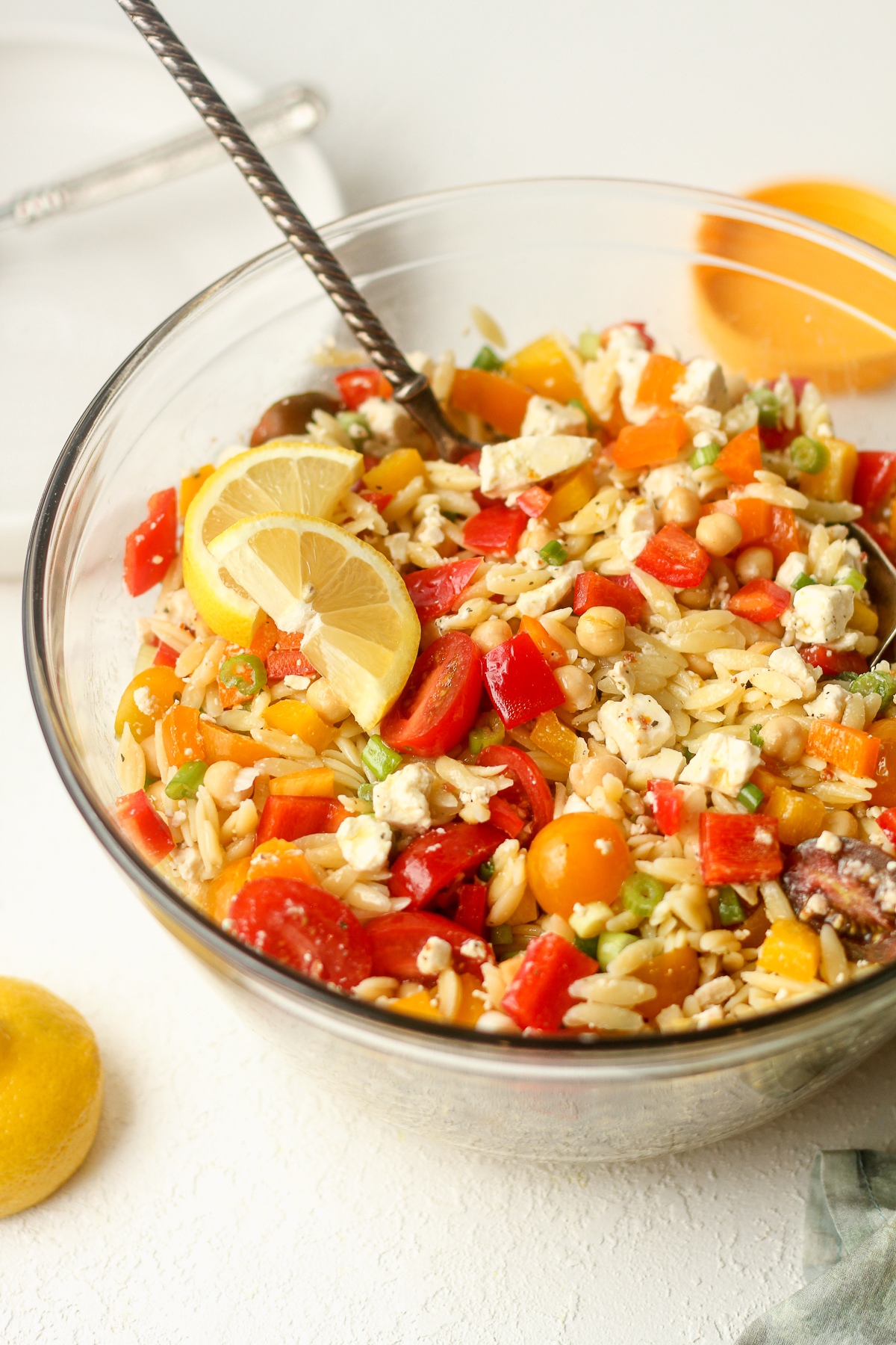 Side view of a orzo pasta salad with veggies.