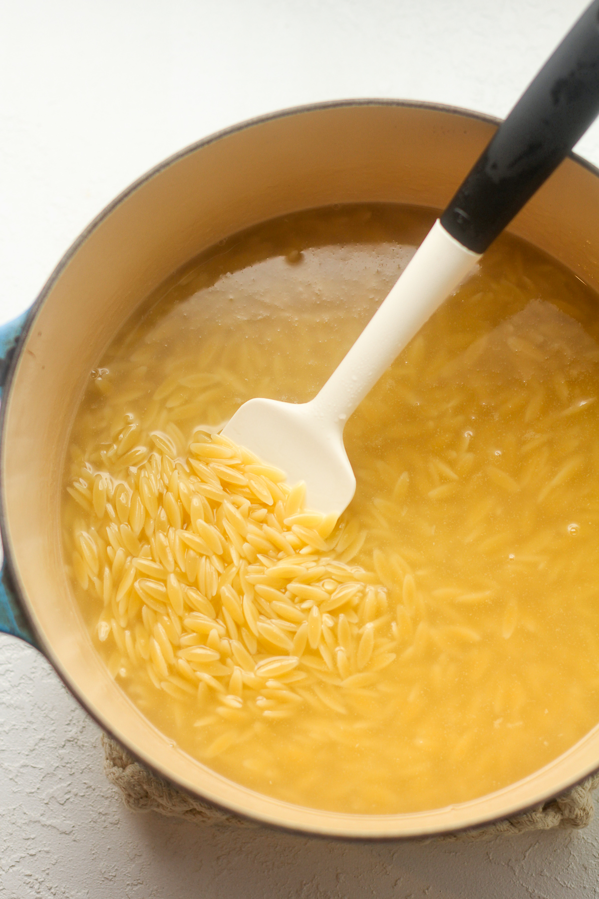 A pot of the orzo pasta in a pot of water.