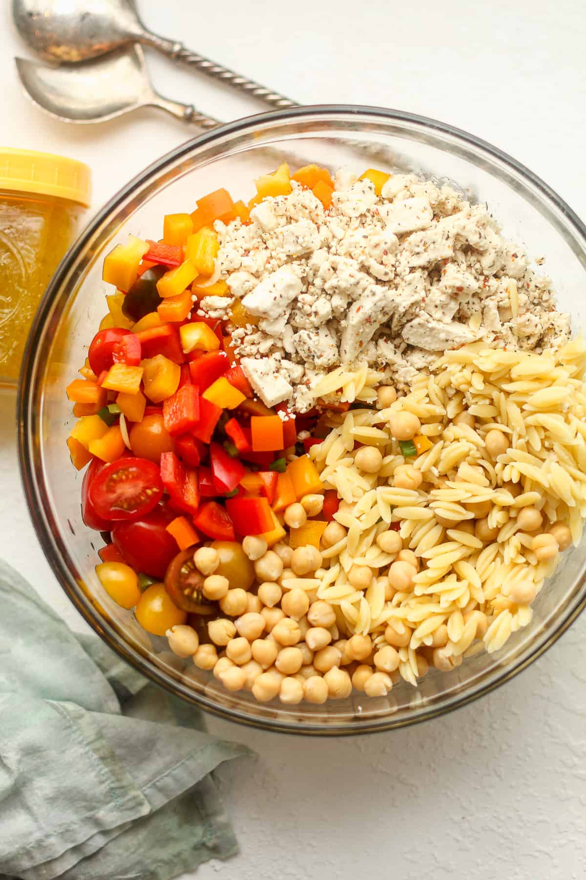A bowl of the pasta salad ingredients, divided by ingredient.
