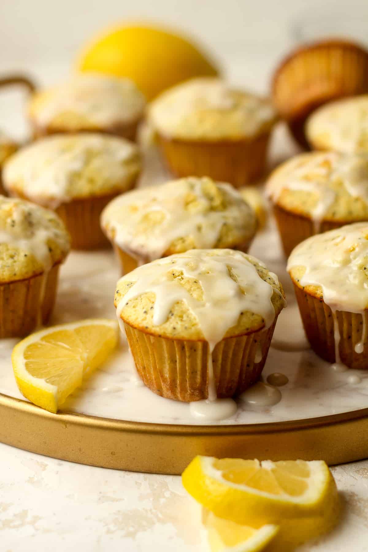 Side view of a tray of lemon muffins with poppy seeds.