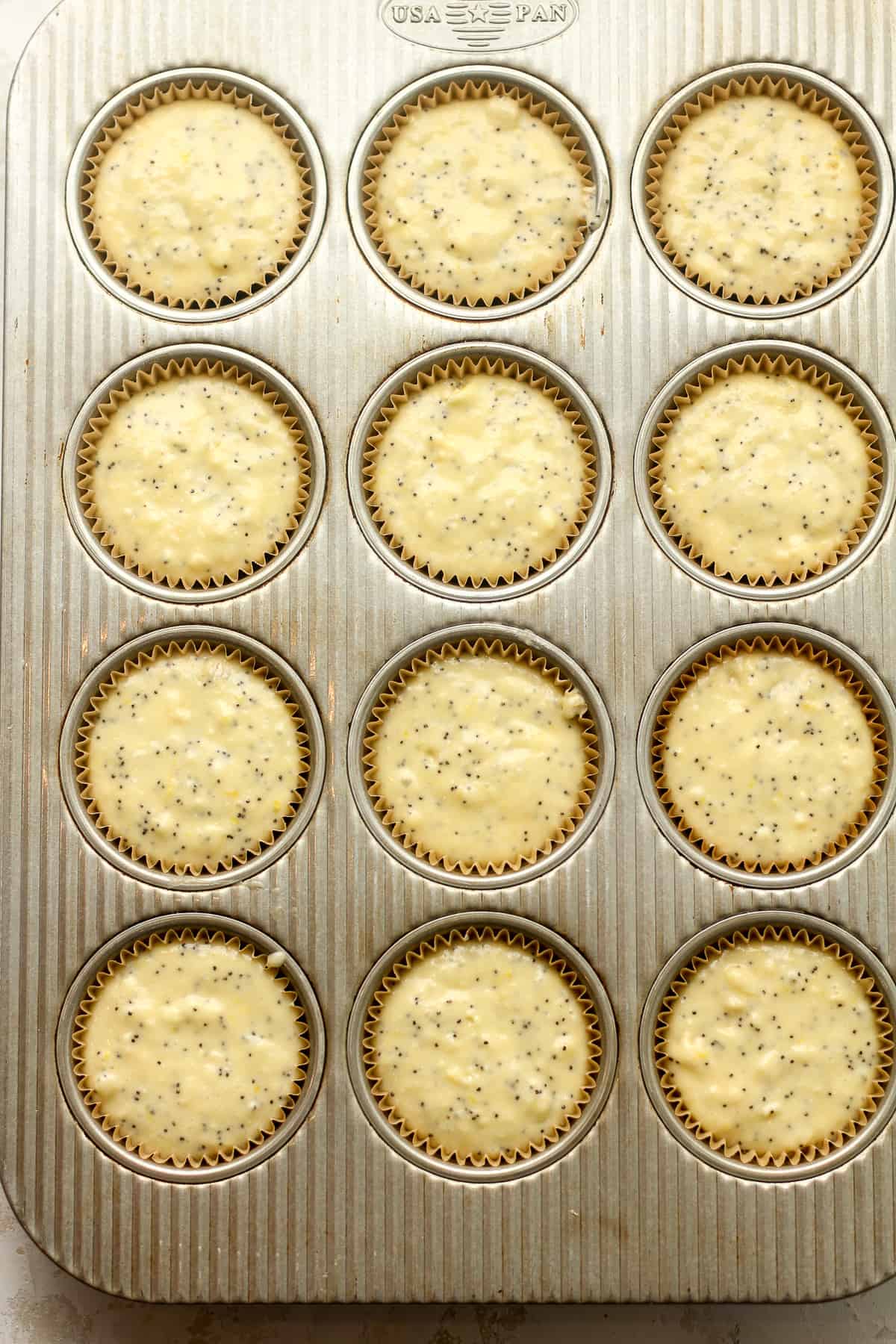 The muffin tin with the liners filled with batter.