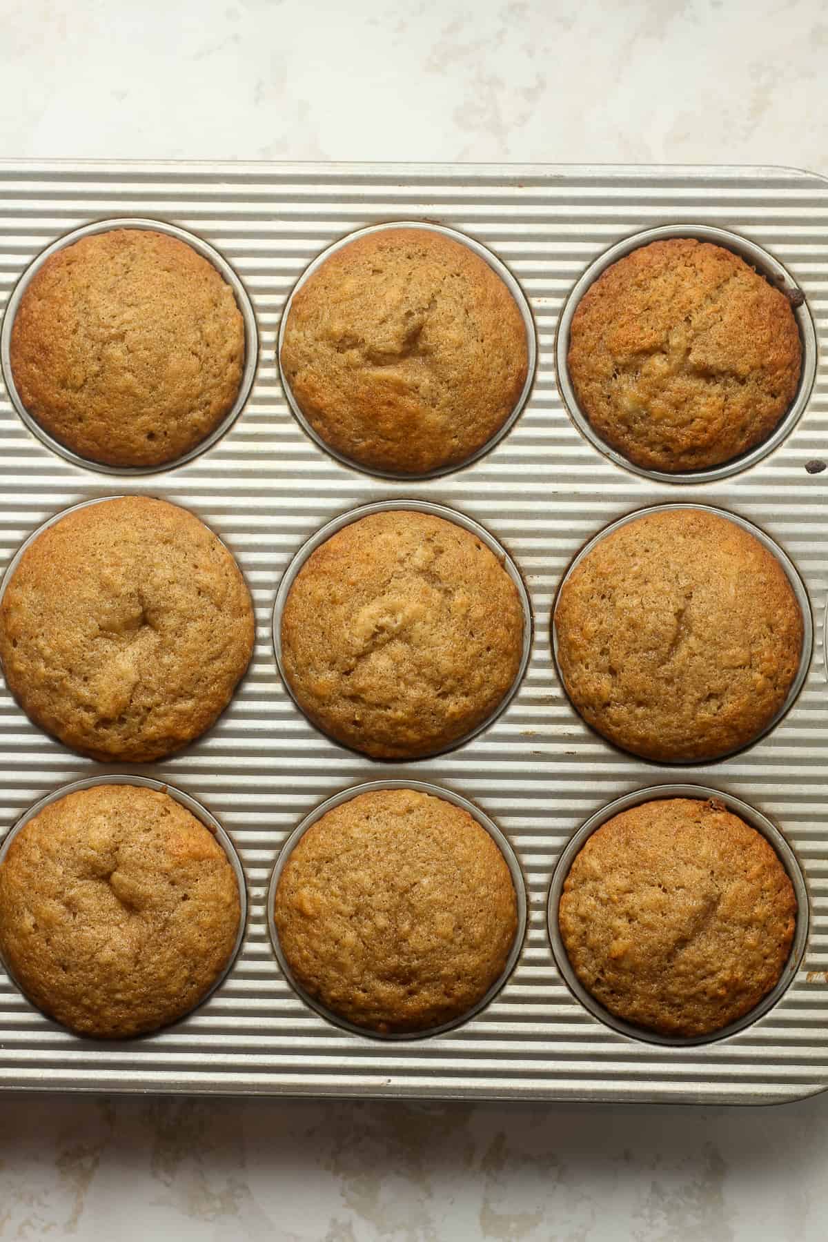 A muffin pan with baked banana muffins.
