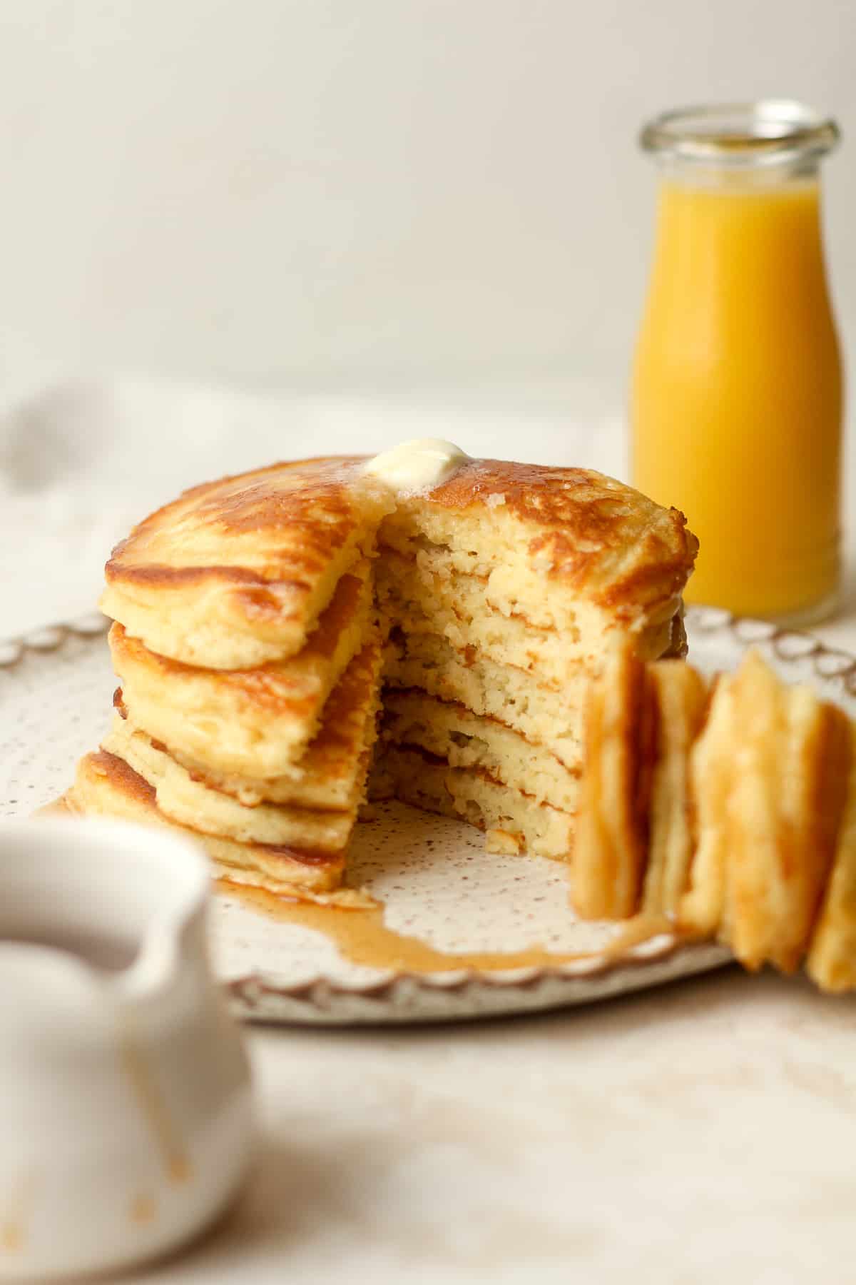 Side view of a stack of pancakes with a big wedge out.