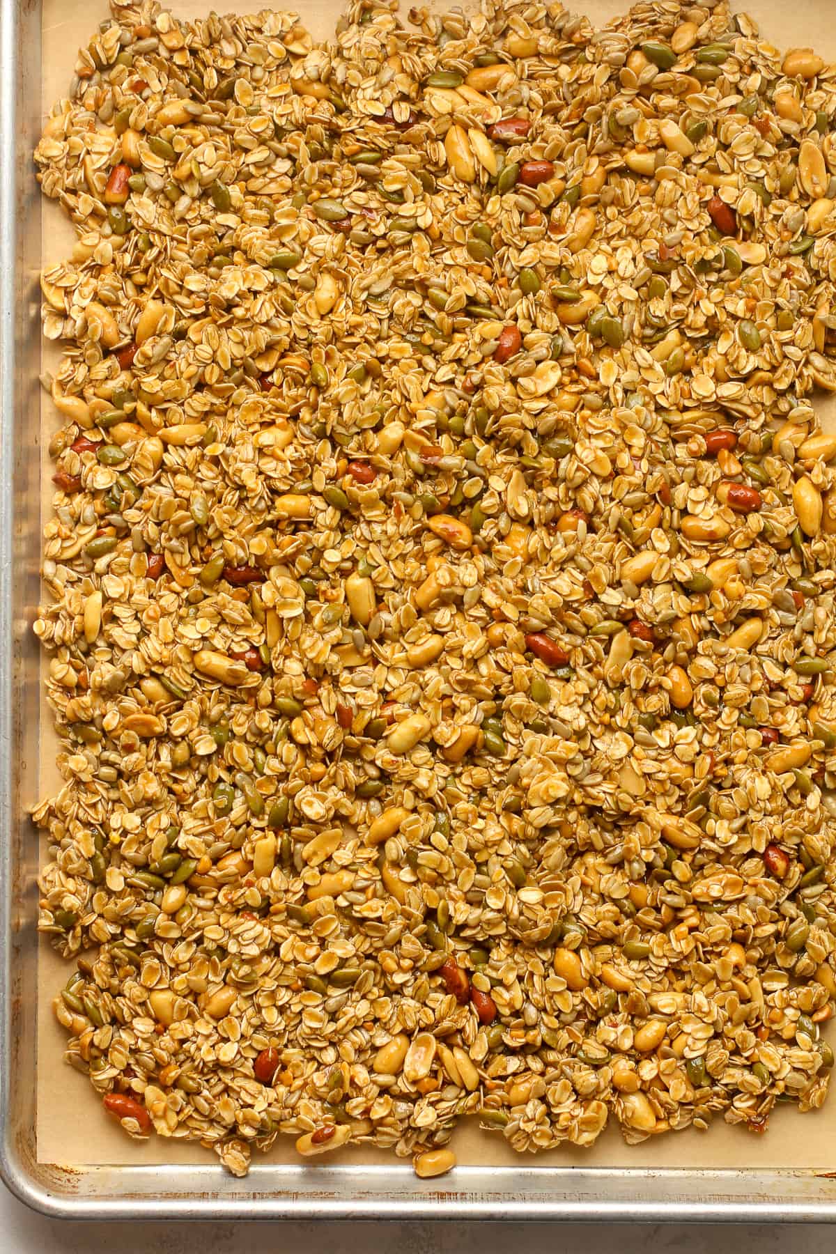 A sheet pan of the granola pressed down.