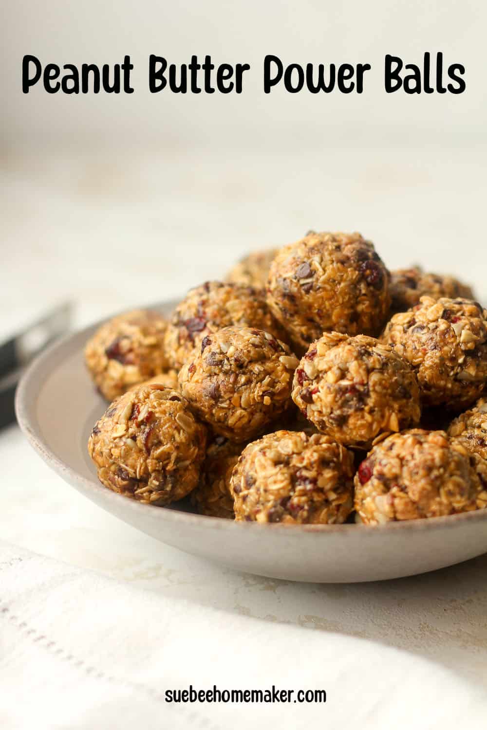 Side view of a bowl of power balls with peanut butter and chocolate chips.