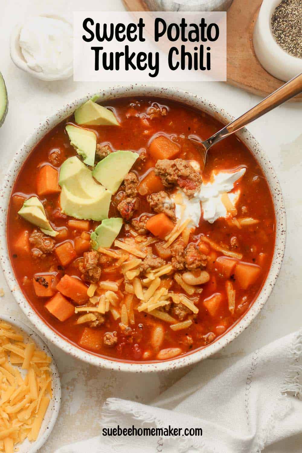 A bowl of sweet potato turkey chili with toppings.