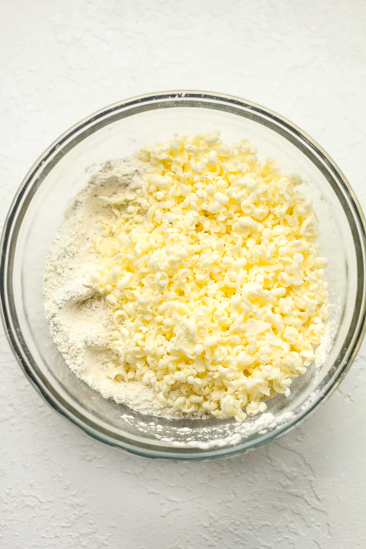 a bowl of the dry ingredients plus frozen butter on top.
