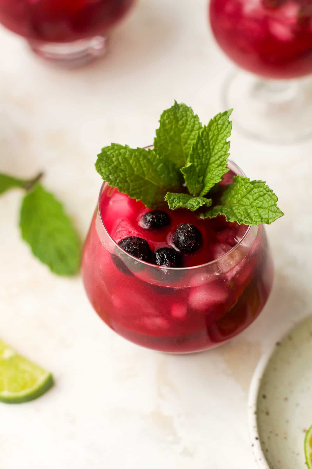 Overhead view of a blueberry mojito mocktail with mint leaves.