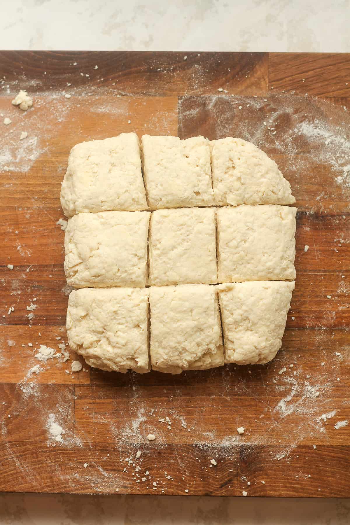 A board with some cut buttermilk biscuits.