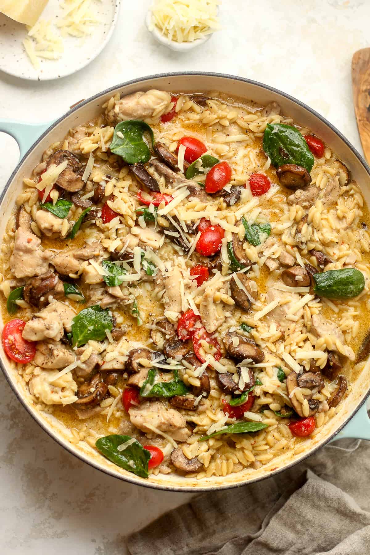 A pot of creamy chicken and orzo with parmesan cheese.