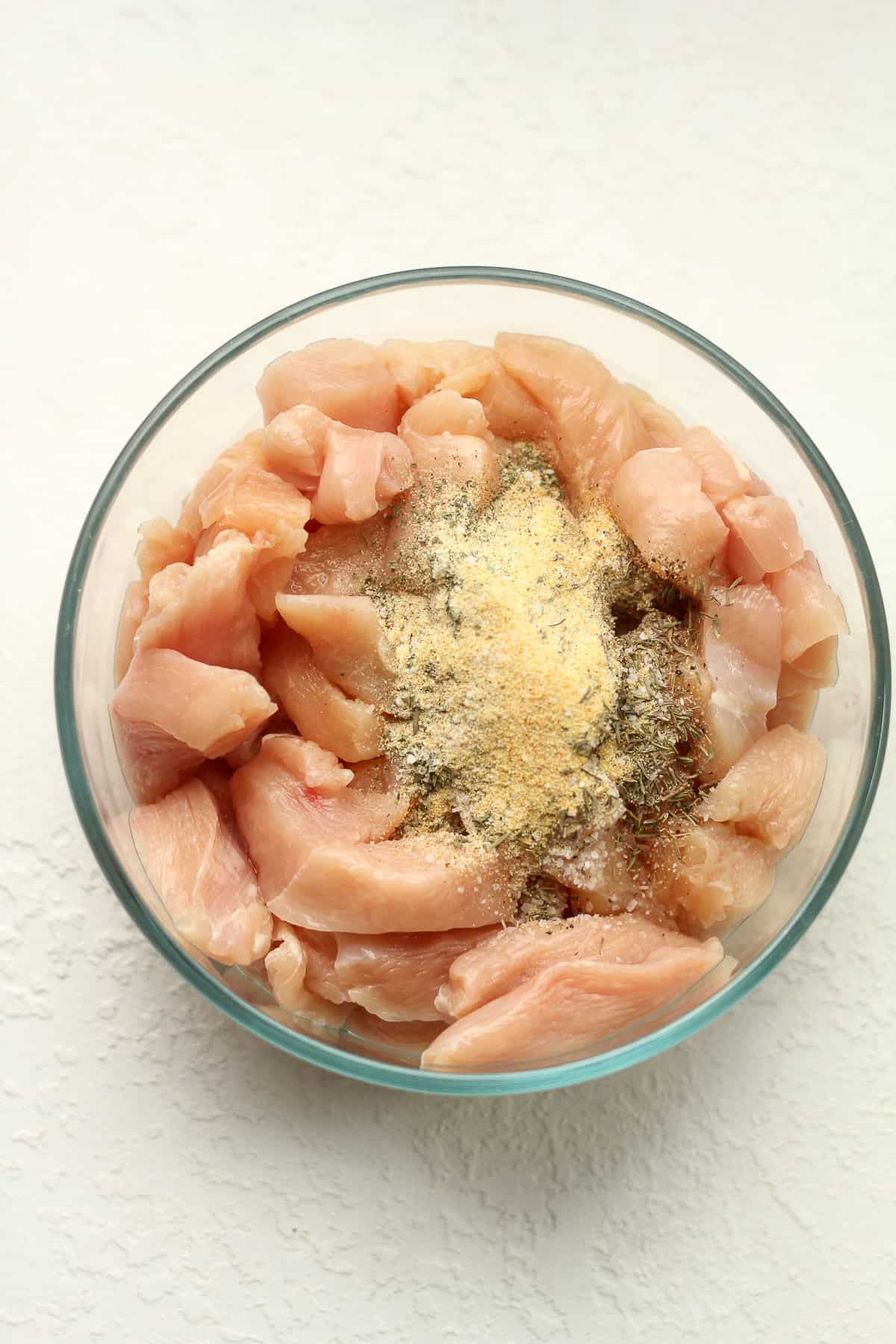 A bowl of the sliced chicken with seasonings on top.