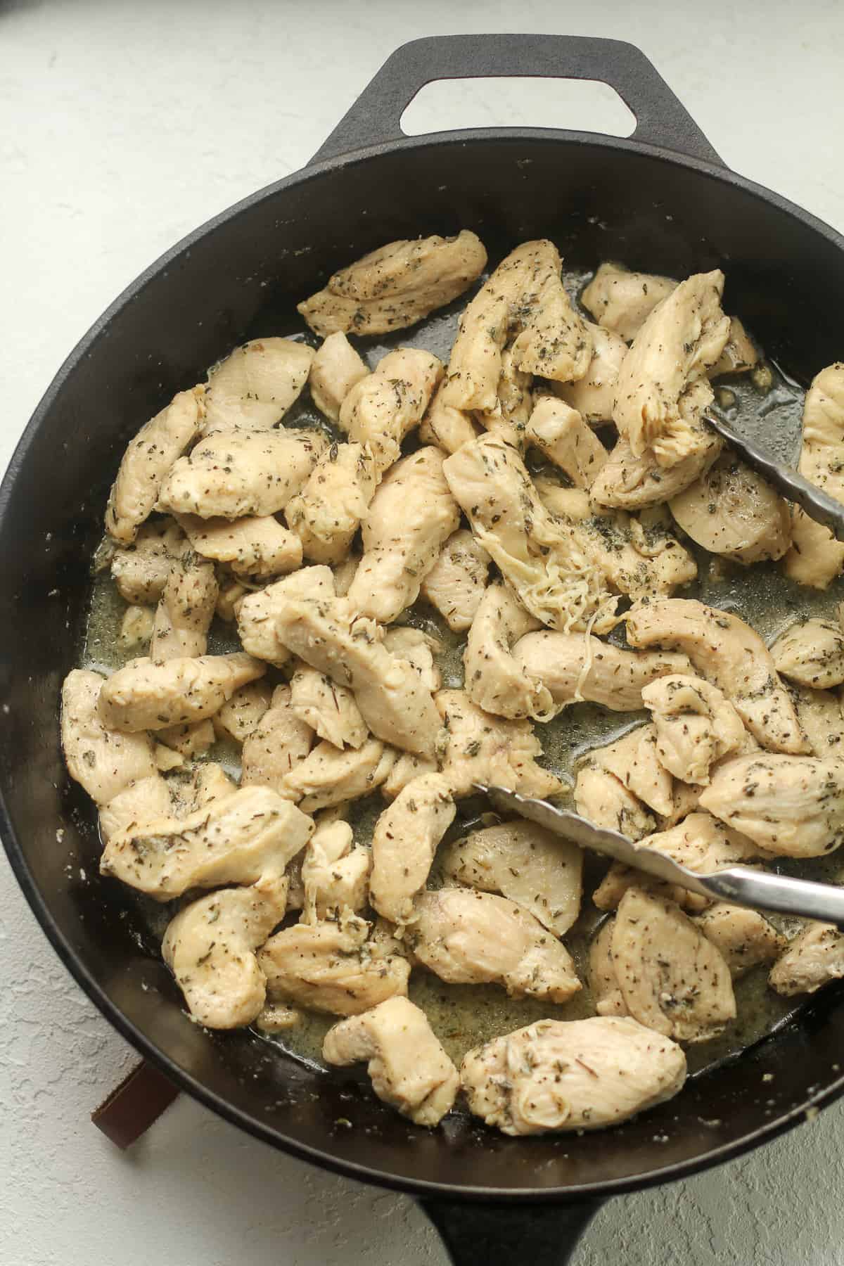 A skillet of sauteed sliced chicken.