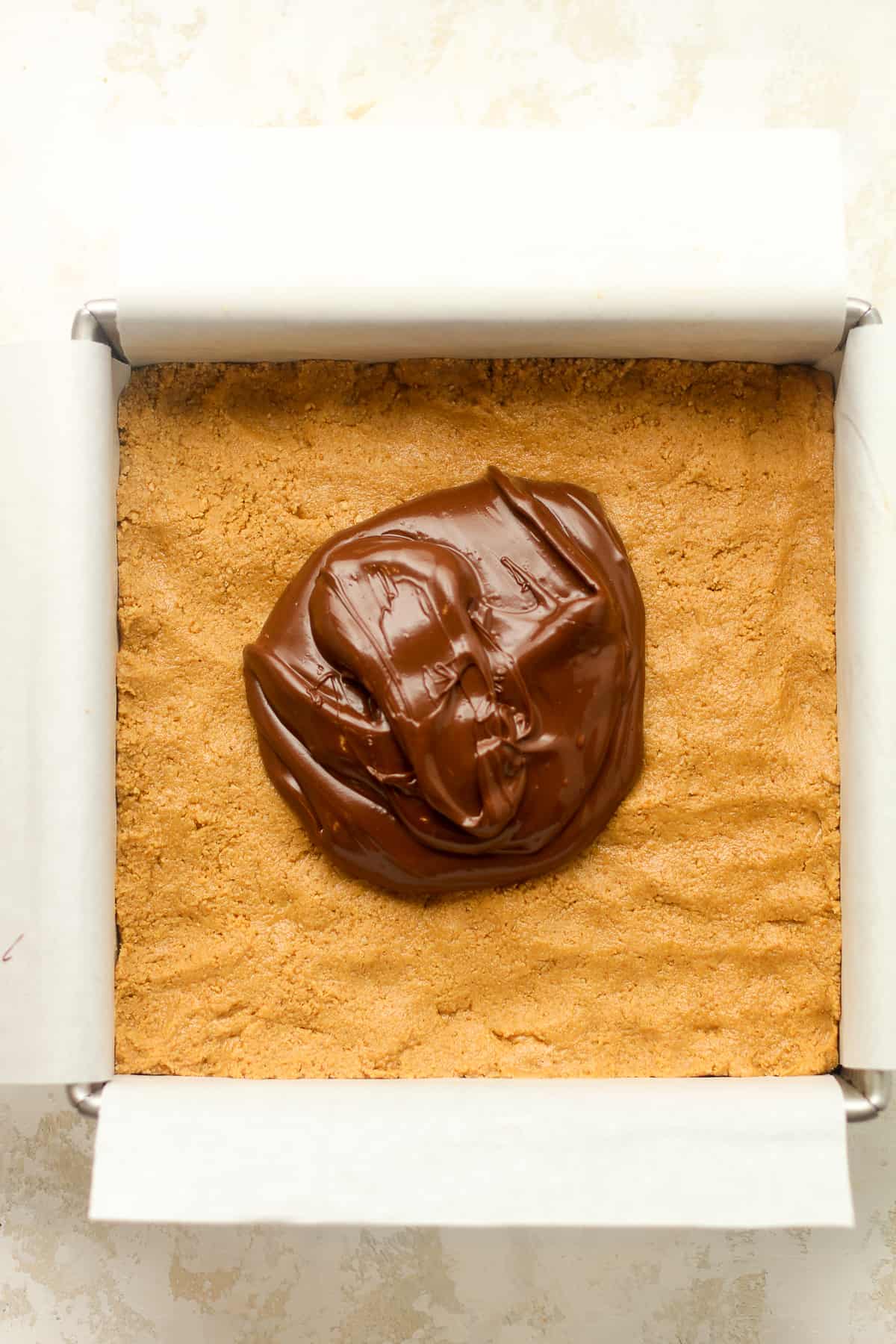 A square of peanut butter mixture plus some creamy chocolate on top before spreading.