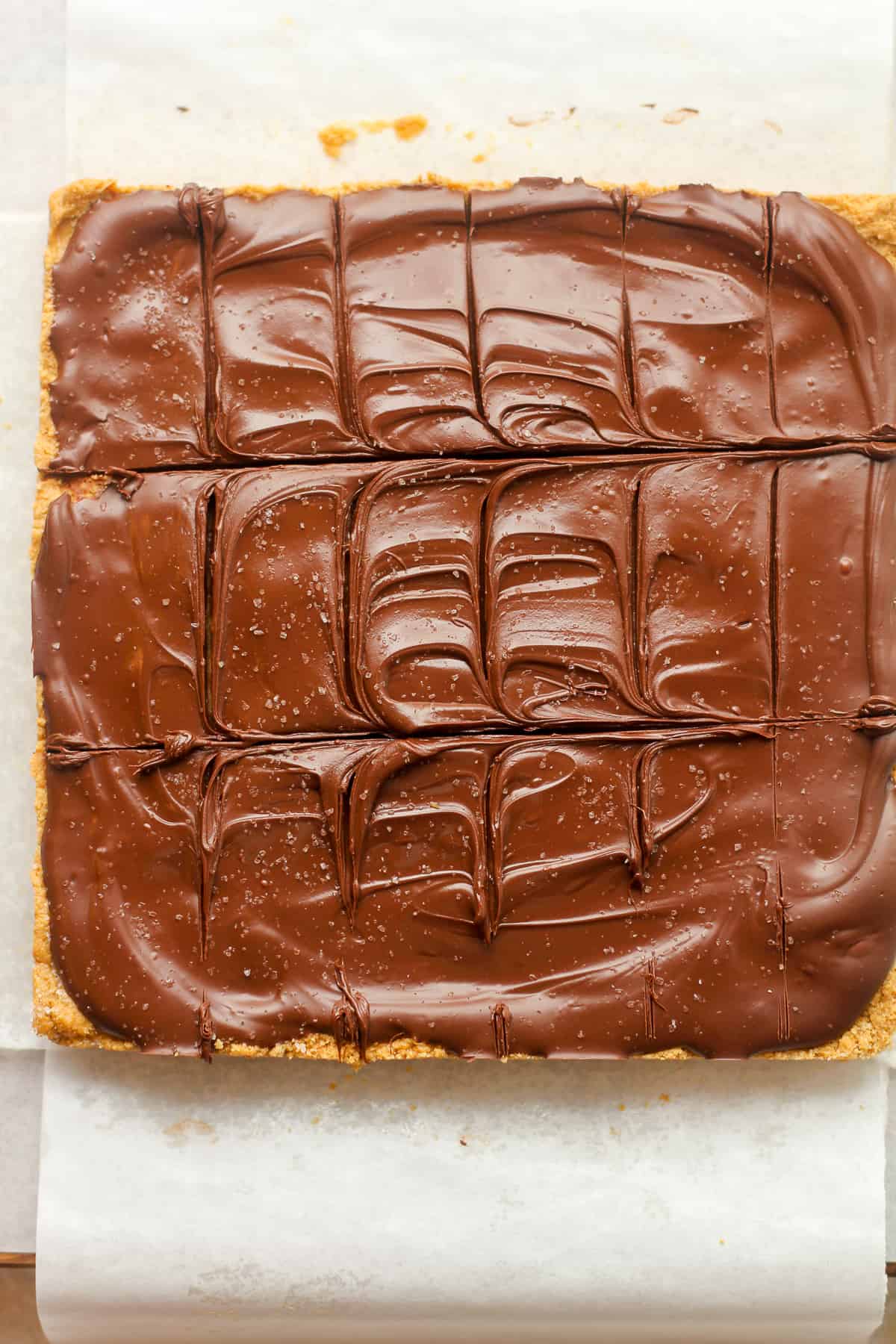 A large square of peanut butter bars with some creamy chocolate on top.