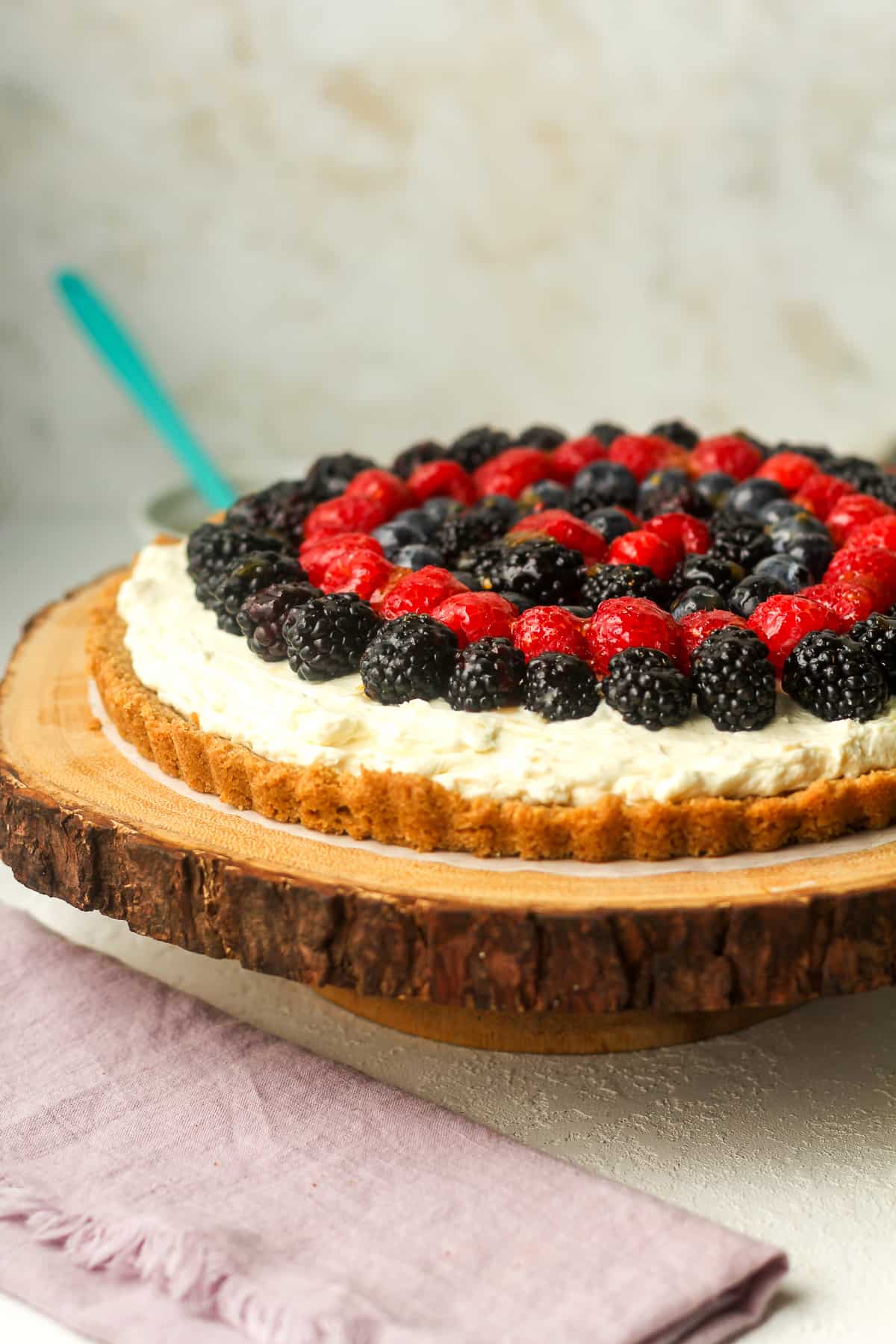 Side view of a graham cracker fruit tart with cream cheese.