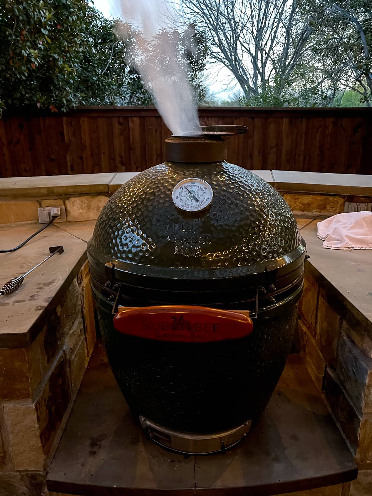 A Big Green Egg smoking out of the top.