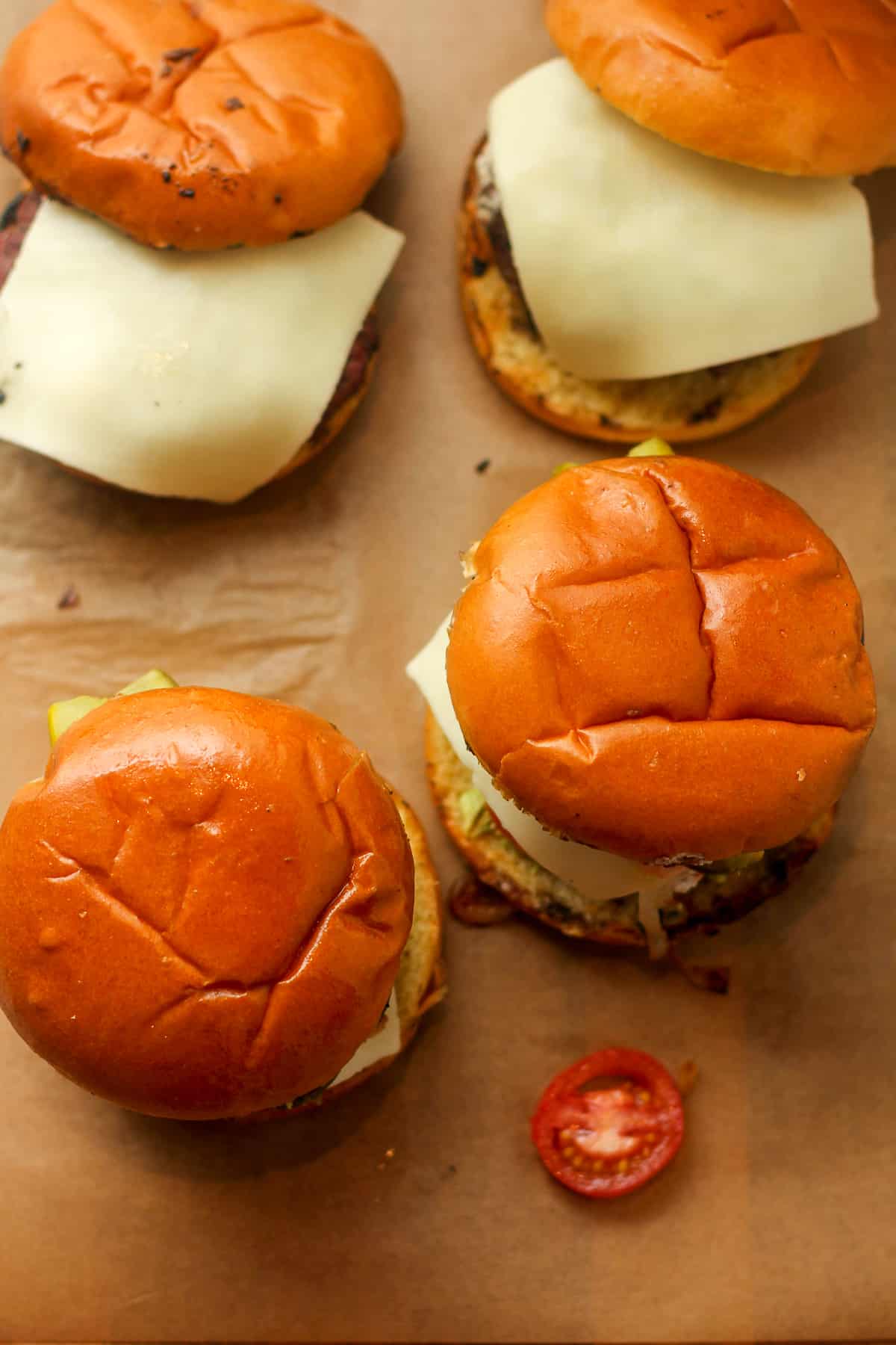 Overhead view of four goat cheese burgers with grilled buns.