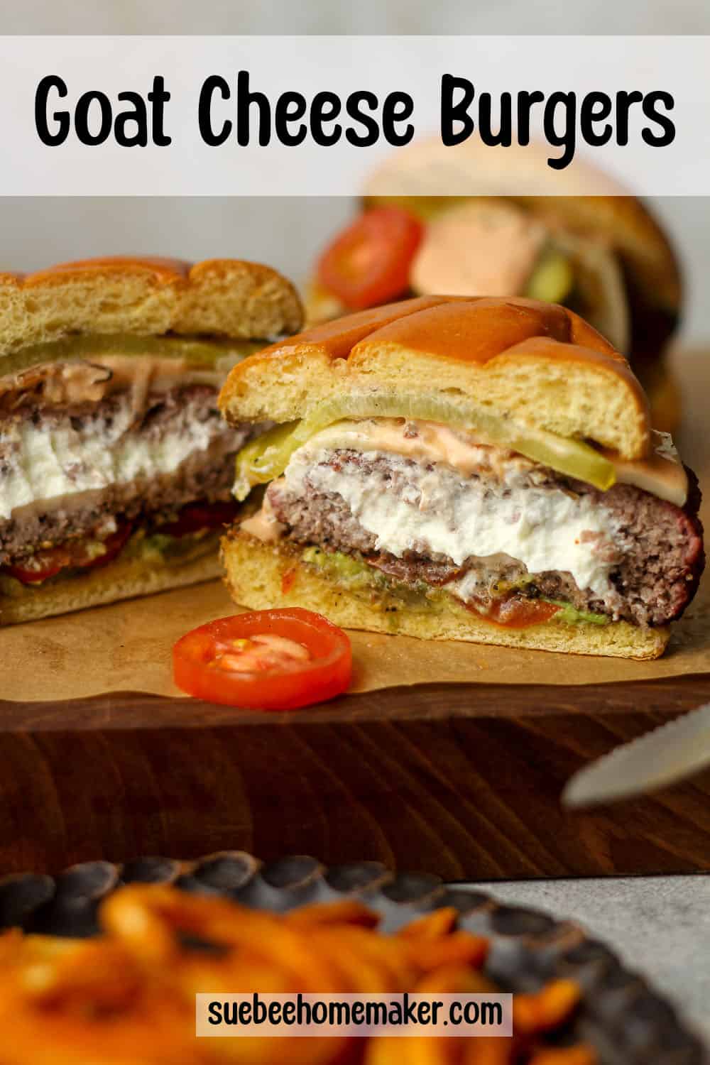A board with some goat cheese burgers, one sliced in half.