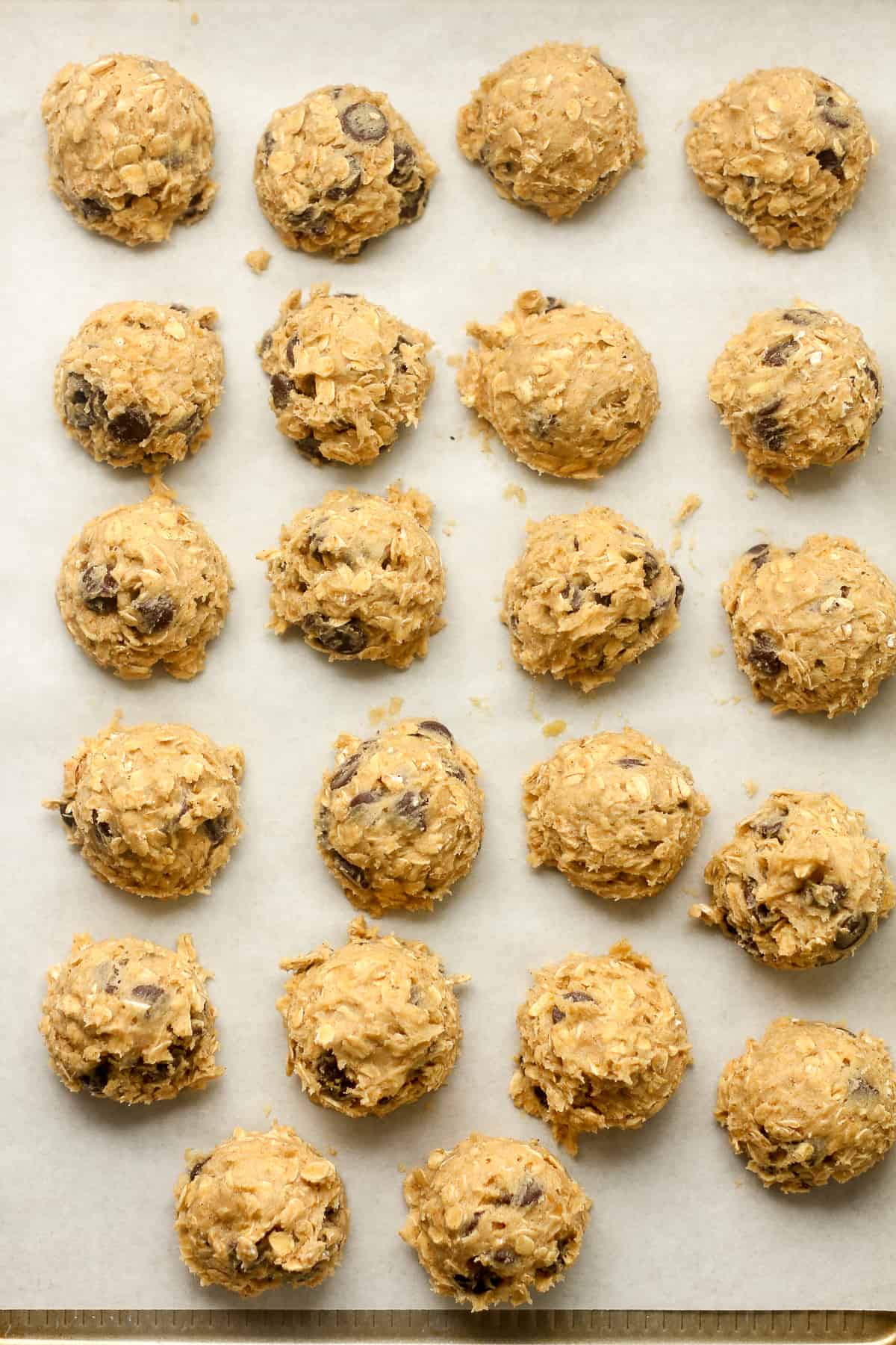 The cookie balls on a white parchment paper.