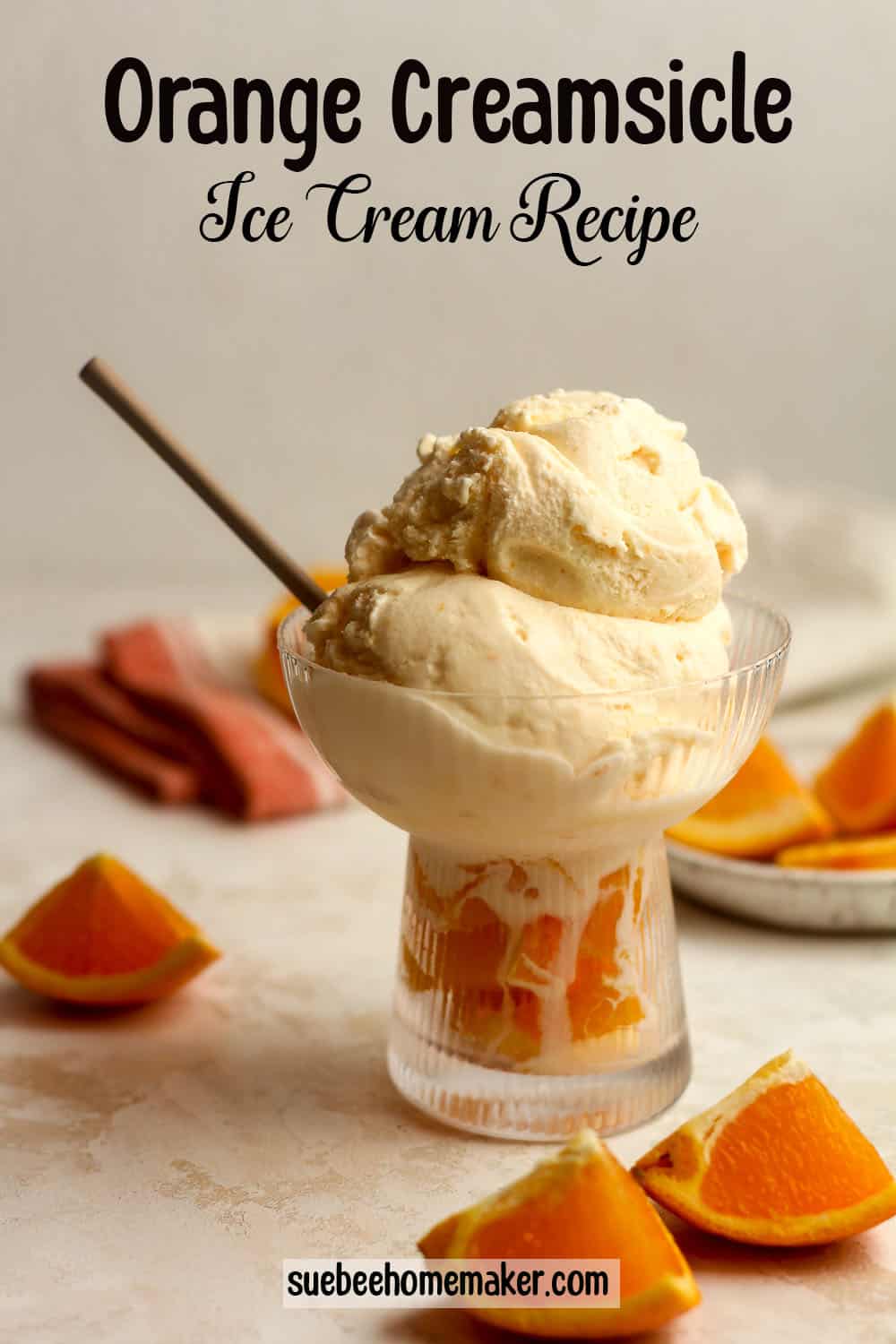A fancy bowl of orange creamsicle ice cream with a spoon and orange wedges around it.