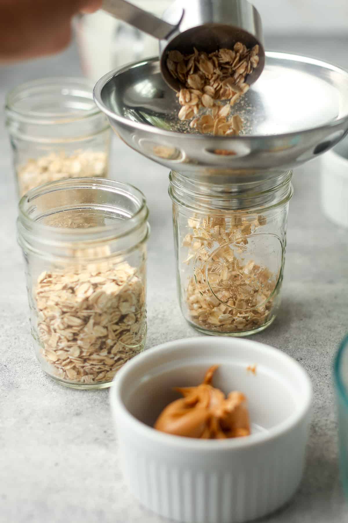A scoop of oatmeal going into a mason jar.