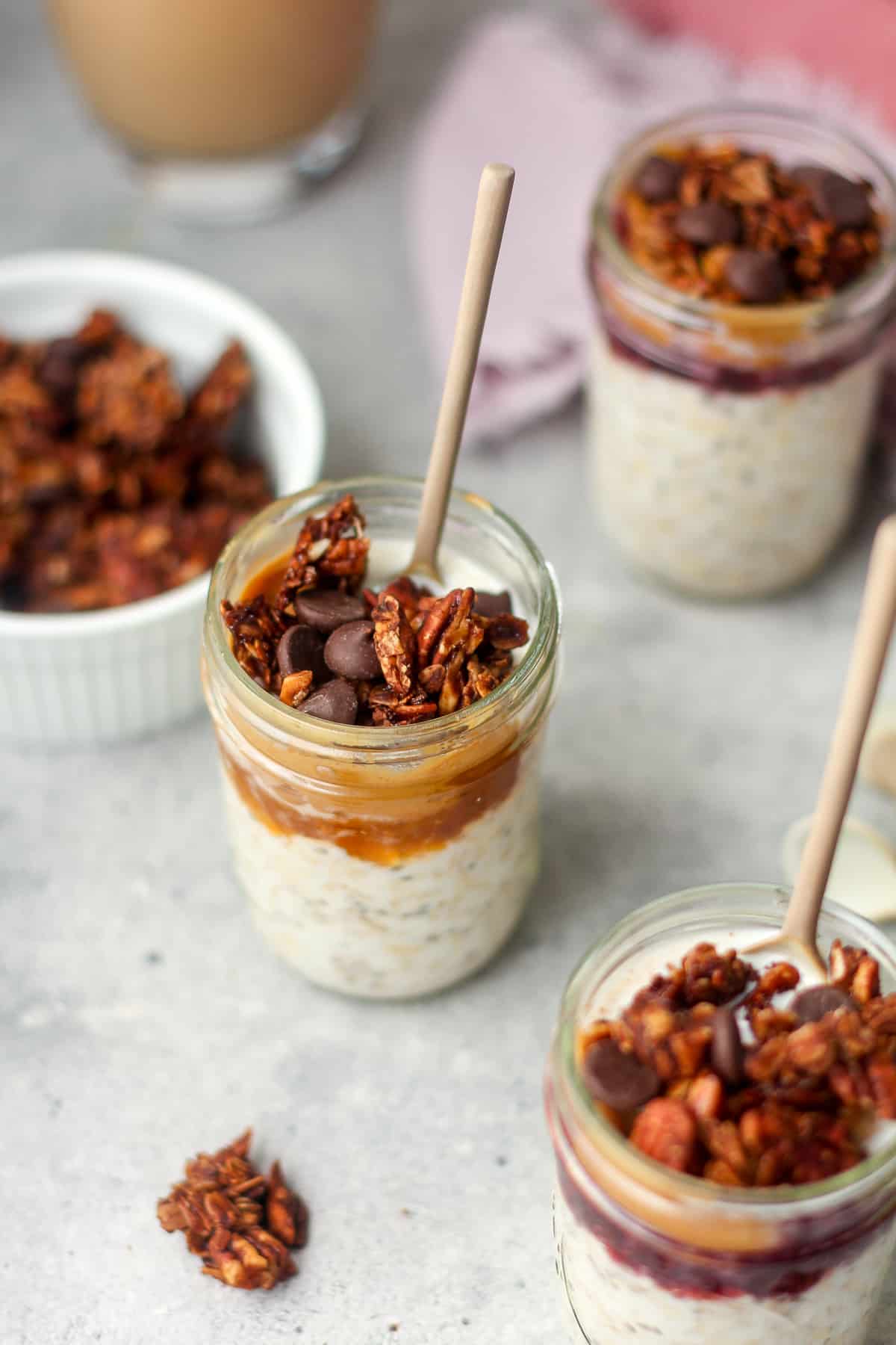 Overhead view of jars of peanut butter and jelly overnight oats with granola on top.
