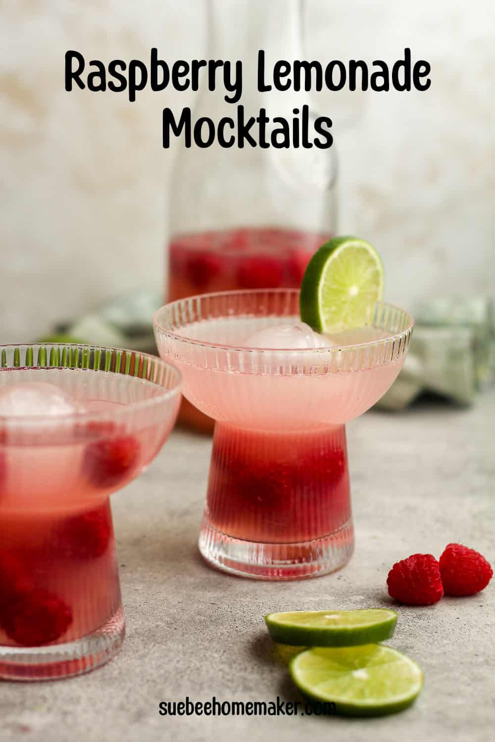 Side view of two fancy glasses of raspberry lemonade mocktails.