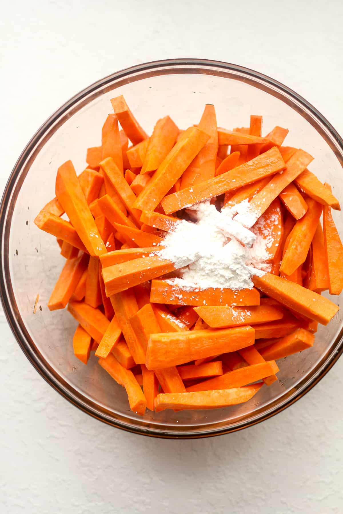 A bowl of raw sweet potato fries with cornstarch.