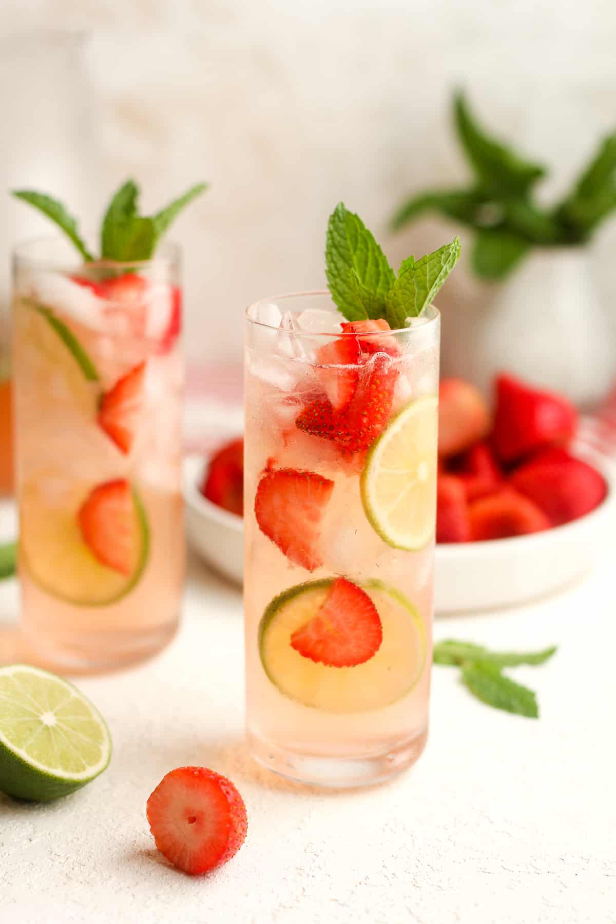 Side view of two tall glasses of strawberry mojito mocktails.